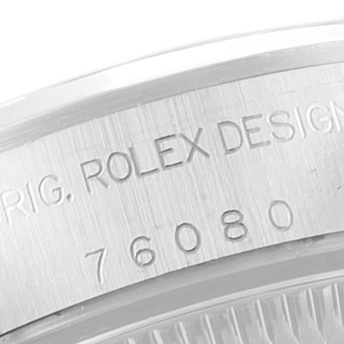 This image shows a close-up of the casing back edge with serial and model information engraved on a Rolex Oyster Perpetual 76080 Women's Stainless Steel Black Dial 76080 Women's Stainless Steel Black Dial watch.