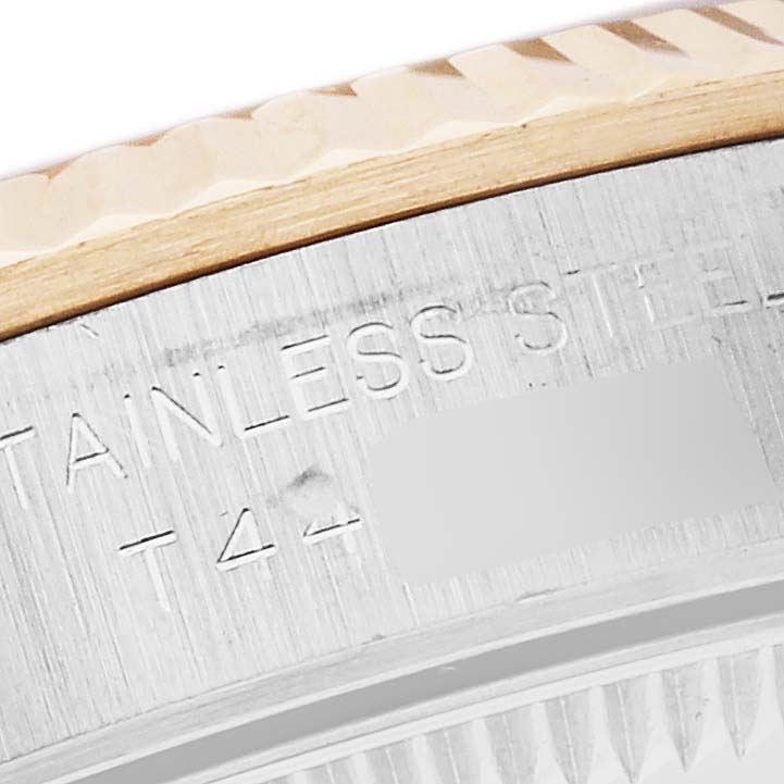 The image shows a close-up of the bezel and case side of a Rolex Oyster Perpetual 67193 Women's Steel and Gold (two tone) Champagne Dial 67193 Women's Steel and Gold (two tone) Champagne Dial, highlighting the fluted bezel and engraved text.