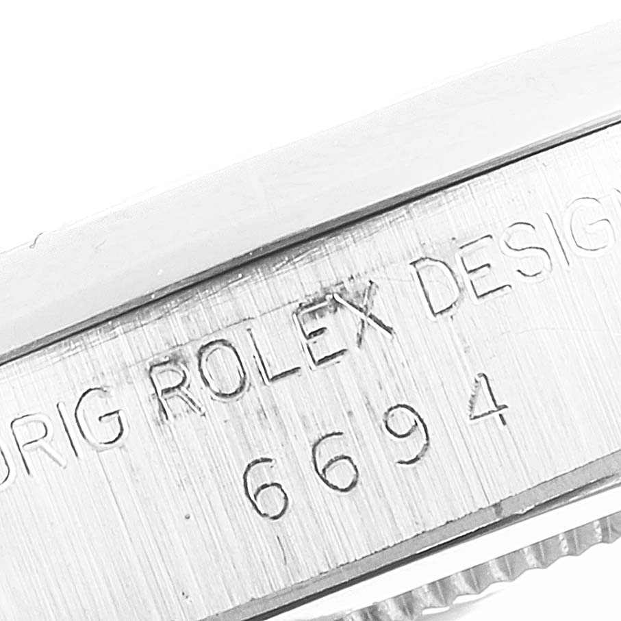 This close-up image shows the engraved text on the side of a Rolex Vintage Collection 6694 Men's Stainless Steel Blue Dial 6694 Men's Stainless Steel Blue Dial model 6694 watch case.