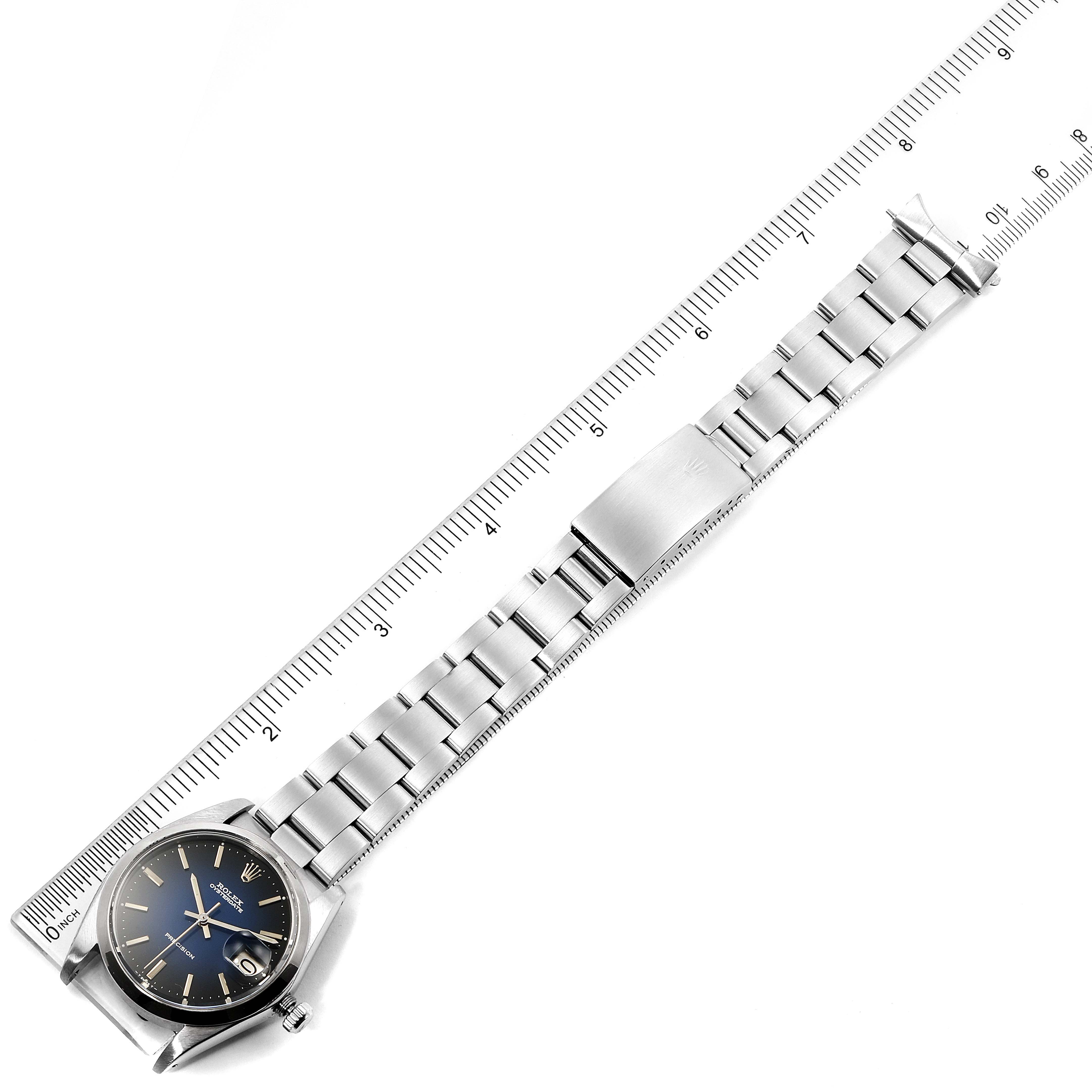 The image shows a Rolex Vintage Collection 6694 Men's Stainless Steel Blue Dial 6694 Men's Stainless Steel Blue Dial model watch from a top view, including the face, bracelet, and clasp next to a ruler for scale.