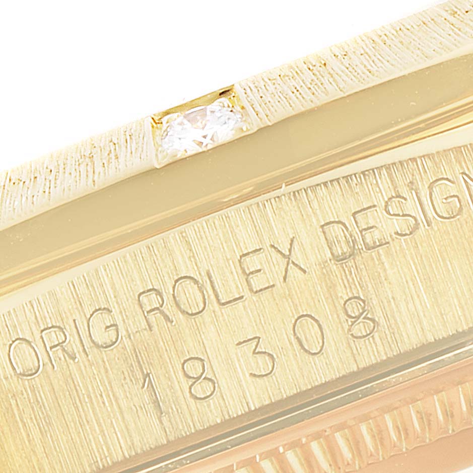 This image shows a close-up of the bezel, the serial number, and part of the case of a Rolex President 18308 Men
s Yellow Gold Mother of Pearl Dial 18308 Men
s Yellow Gold Mother of Pearl Dial model watch.