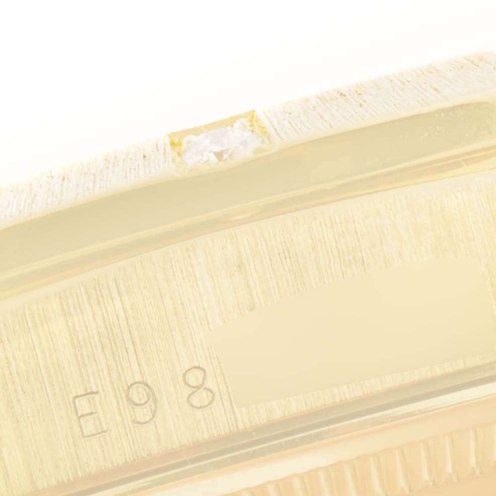 This image shows a close-up of the side case of a Rolex President 18308 Men
s Yellow Gold Mother of Pearl Dial 18308 Men
s Yellow Gold Mother of Pearl Dial model watch, highlighting part of the bezel and serial engraving.