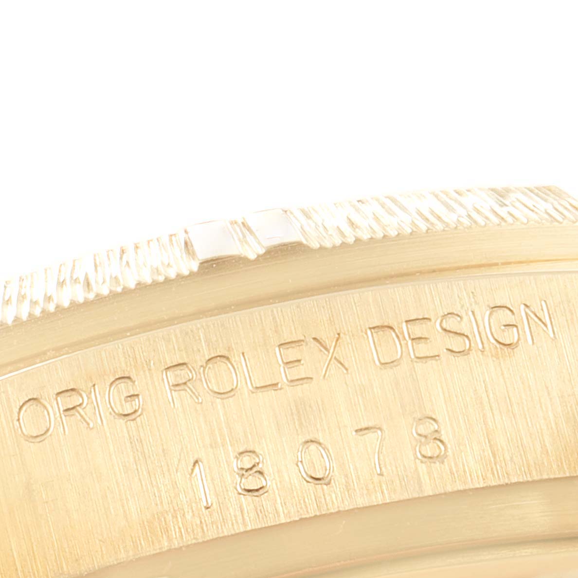 The image shows a close-up of the side of a Rolex President 18078 Men's Yellow Gold Champagne Dial 18078 Men's Yellow Gold Champagne Dial model watch, highlighting the fluted bezel and engraved serial numbers.