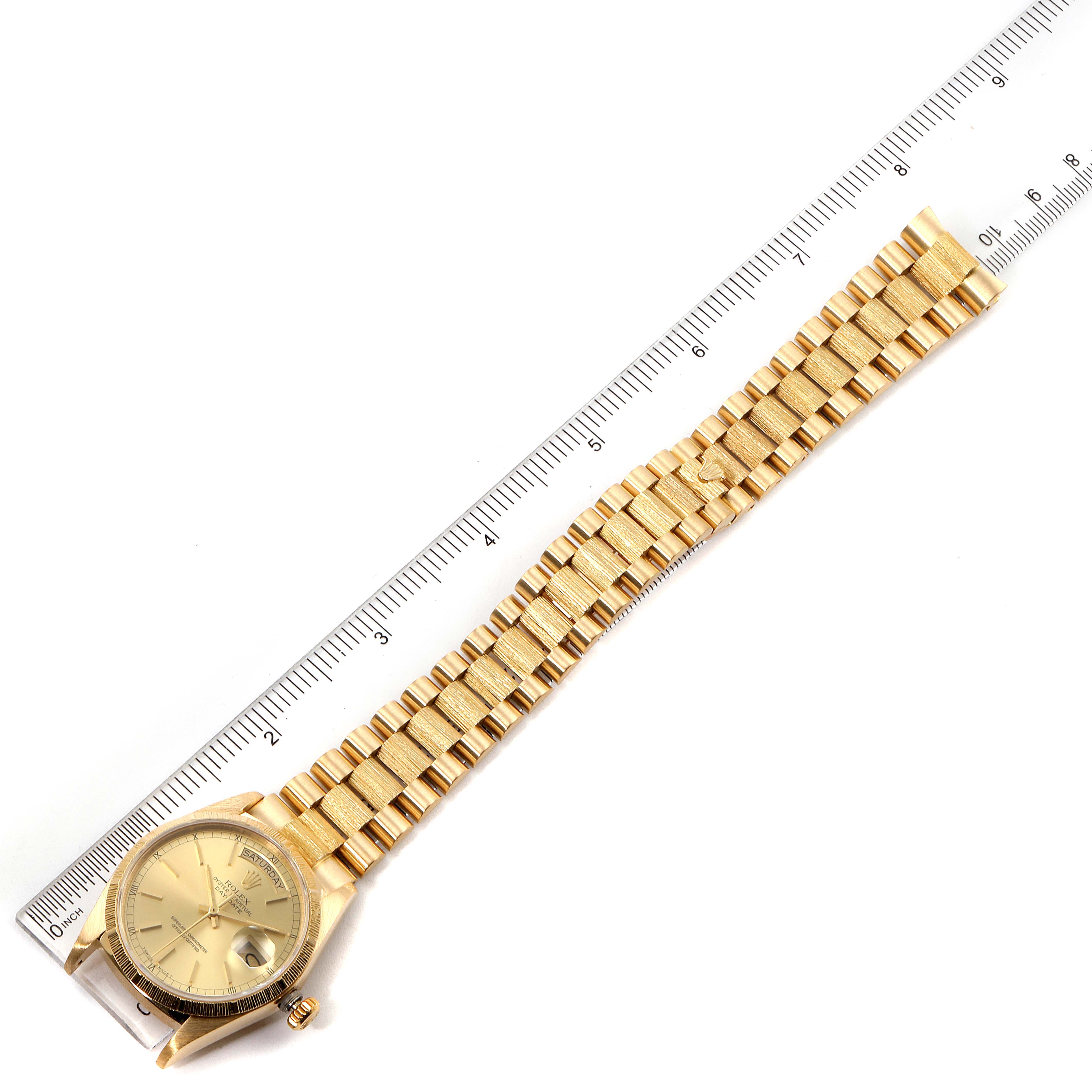 The image shows a Rolex President 18078 Men
s Yellow Gold Champagne Dial 18078 Men
s Yellow Gold Champagne Dial model watch, laid flat next to a ruler, displaying the watch face and bracelet.