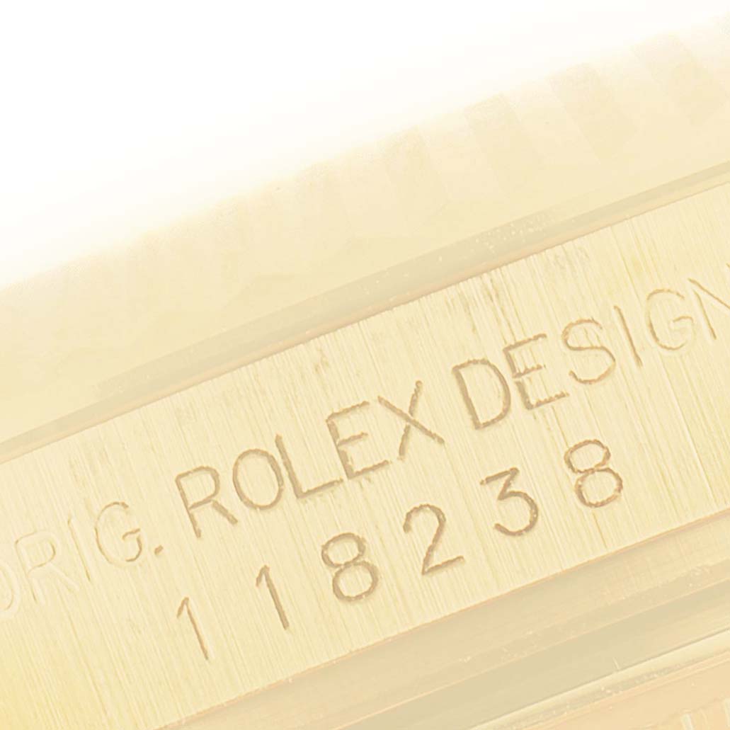 This close-up image shows the side of a Rolex President 118238 Men
s Yellow Gold Champagne Dial 118238 Men
s Yellow Gold Champagne Dial model watch with the engraved design and model number.