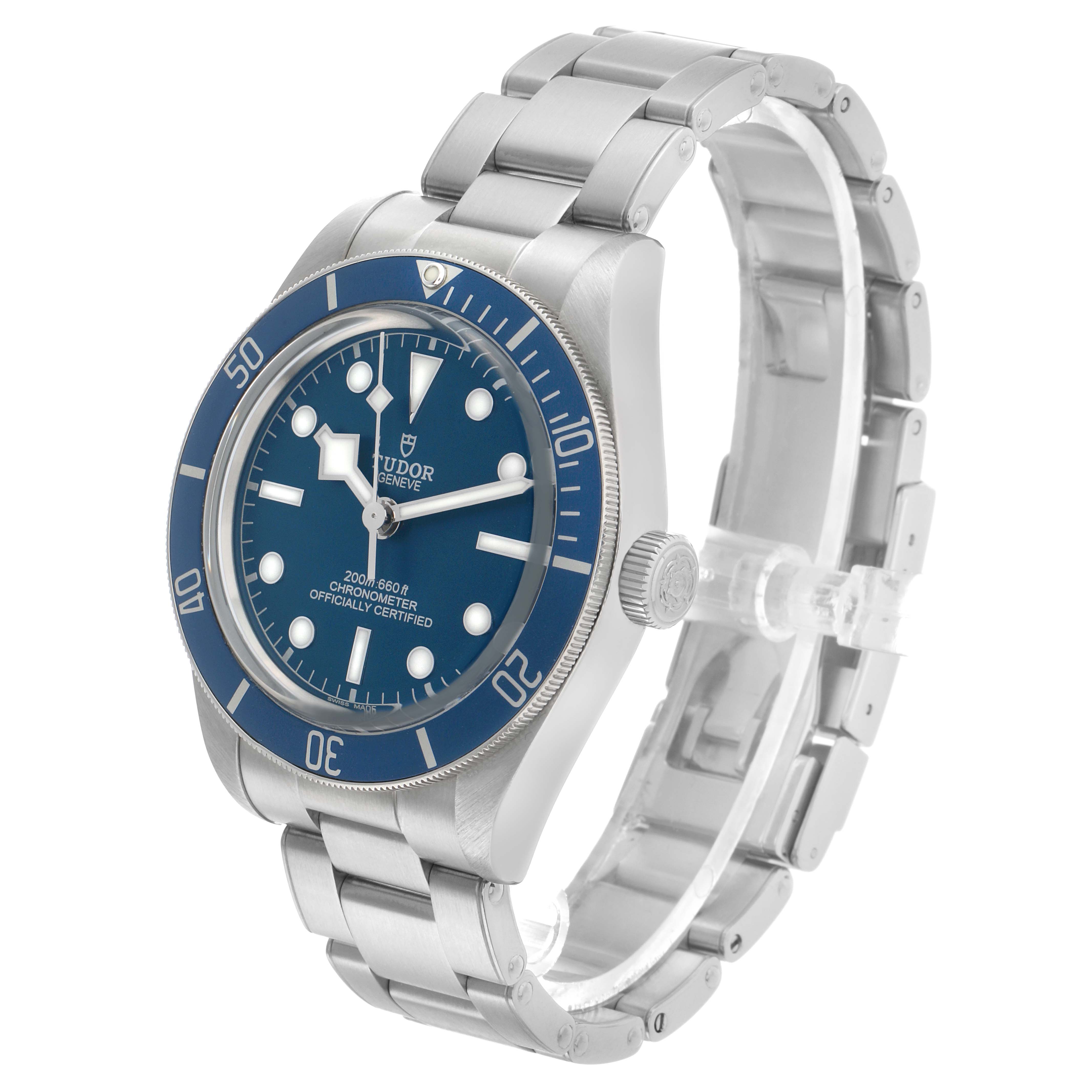 The Tudor Heritage Black Bay 79030B Men's Stainless Steel Blue Dial watch is shown at a three-quarter angle, highlighting the dial, bezel, and stainless steel bracelet.