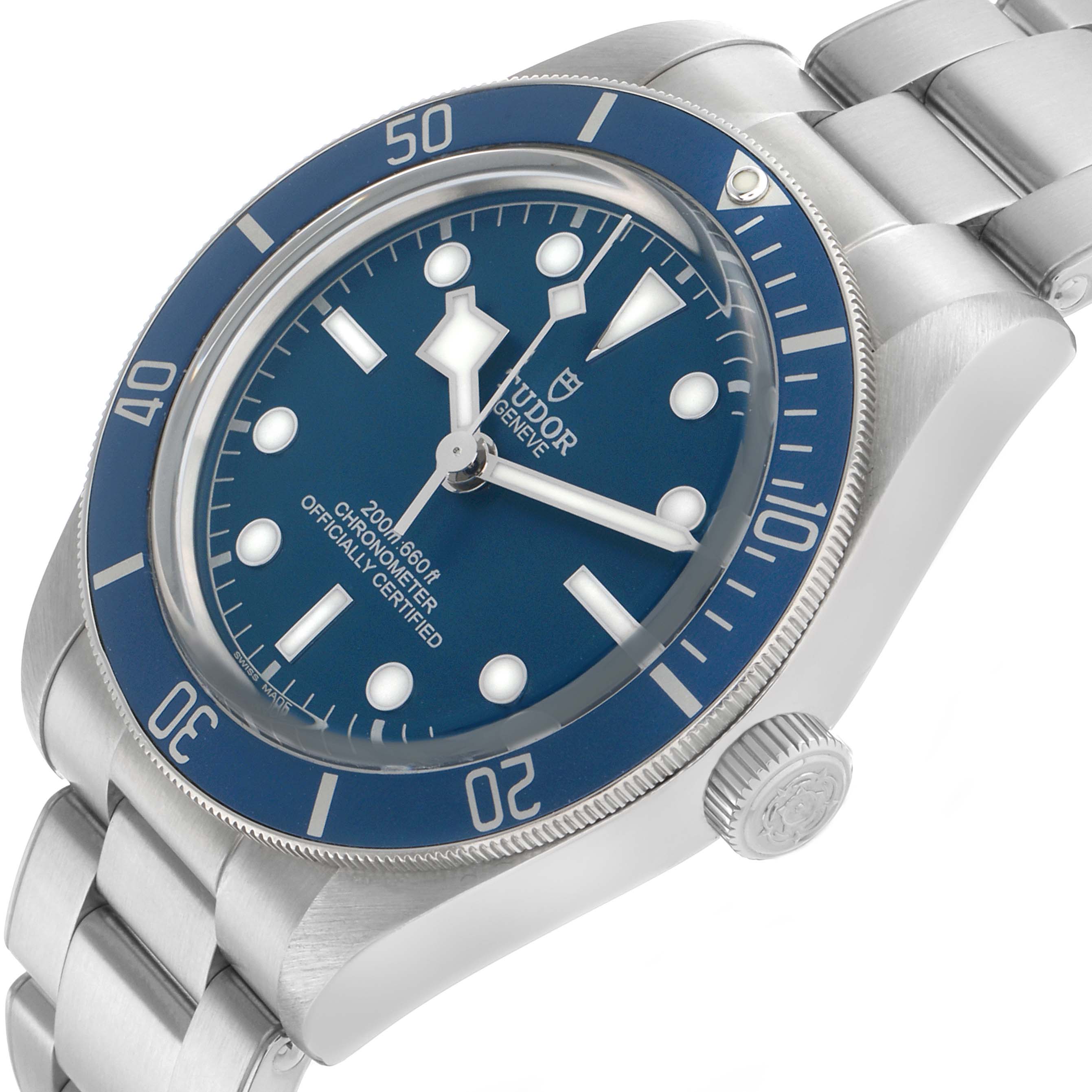 The Tudor Heritage Black Bay 79030B Men's Stainless Steel Blue Dial watch is shown from an angled side view, highlighting the blue bezel, dial, crown, and bracelet.