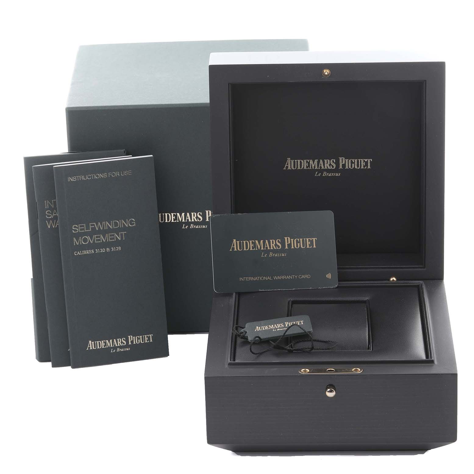 The image shows the packaging and accessories of an Audemars Piguet Royal Oak 15400ST.OO.1220ST.02.A Men's Stainless Steel Silver Dial 15400ST.OO.1220ST.02.A Men's Stainless Steel Silver Dial watch, including manuals and a warranty card.