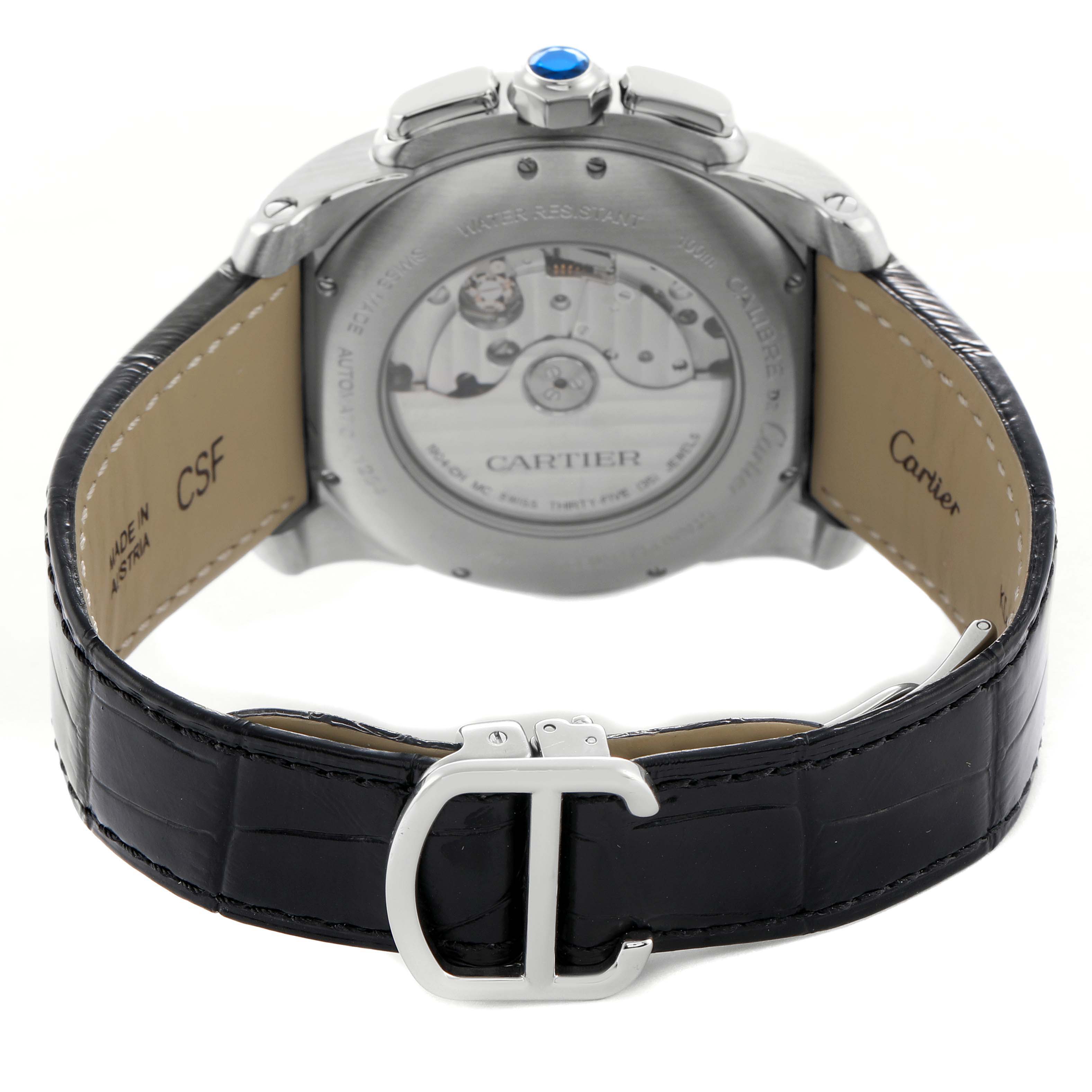 The Calibre de Cartier watch is shown from the rear, highlighting the case back and leather strap with a clasp.
