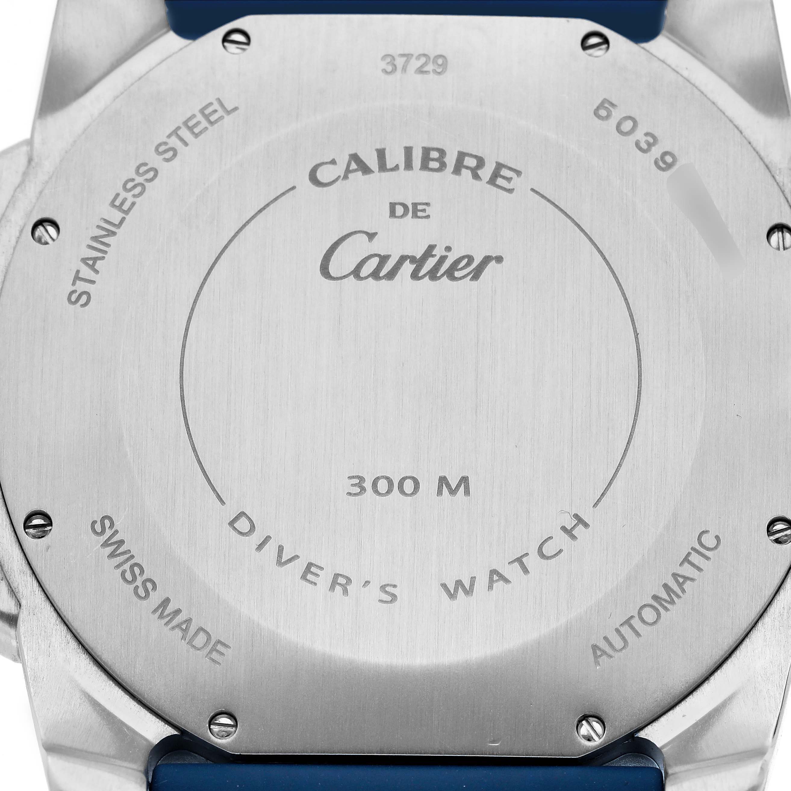 The image shows the back of the Calibre de Cartier watch, highlighting its stainless steel casing and detailing.