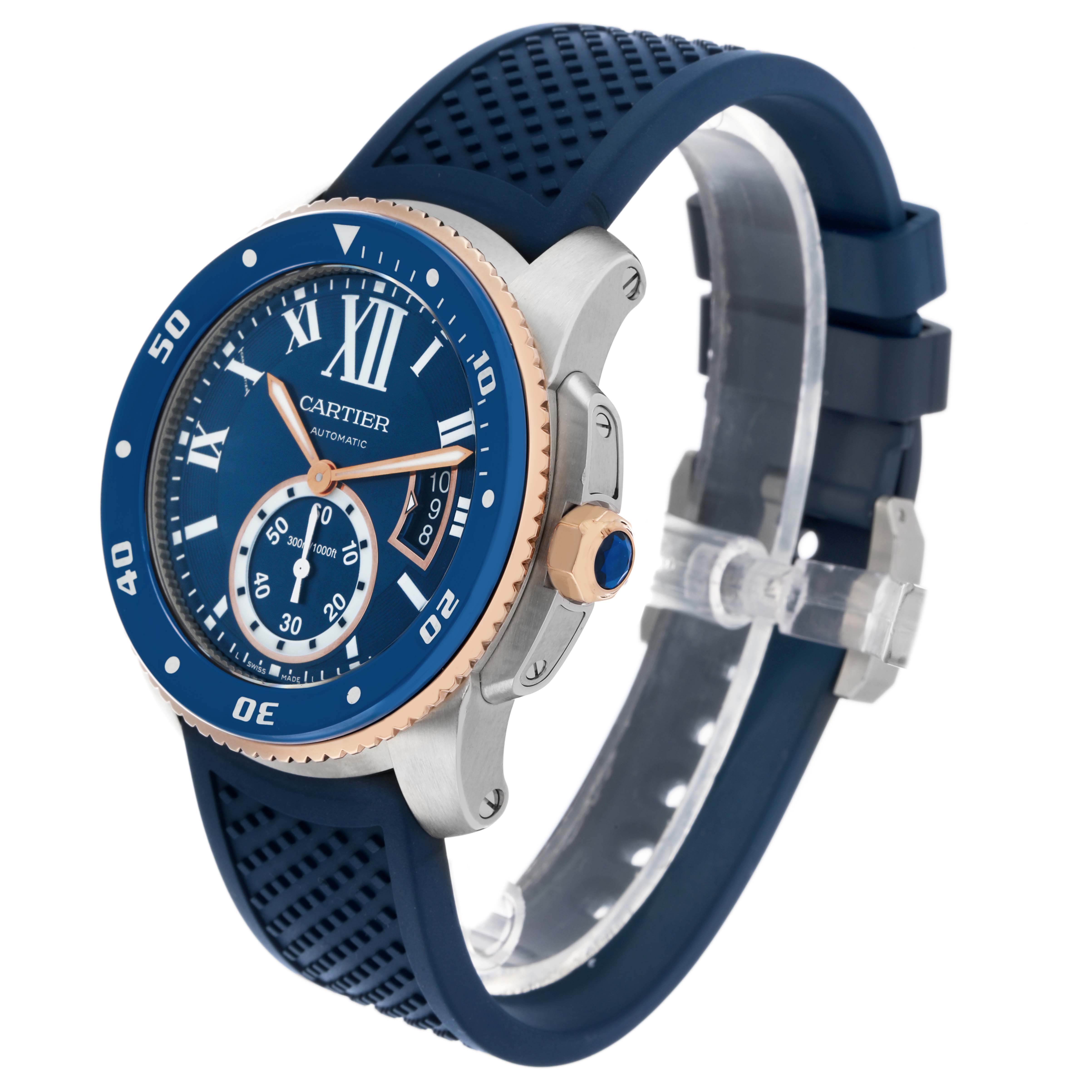 The Calibre de Cartier watch is shown at a three-quarter angle, highlighting the blue dial, bezel, crown, and strap.