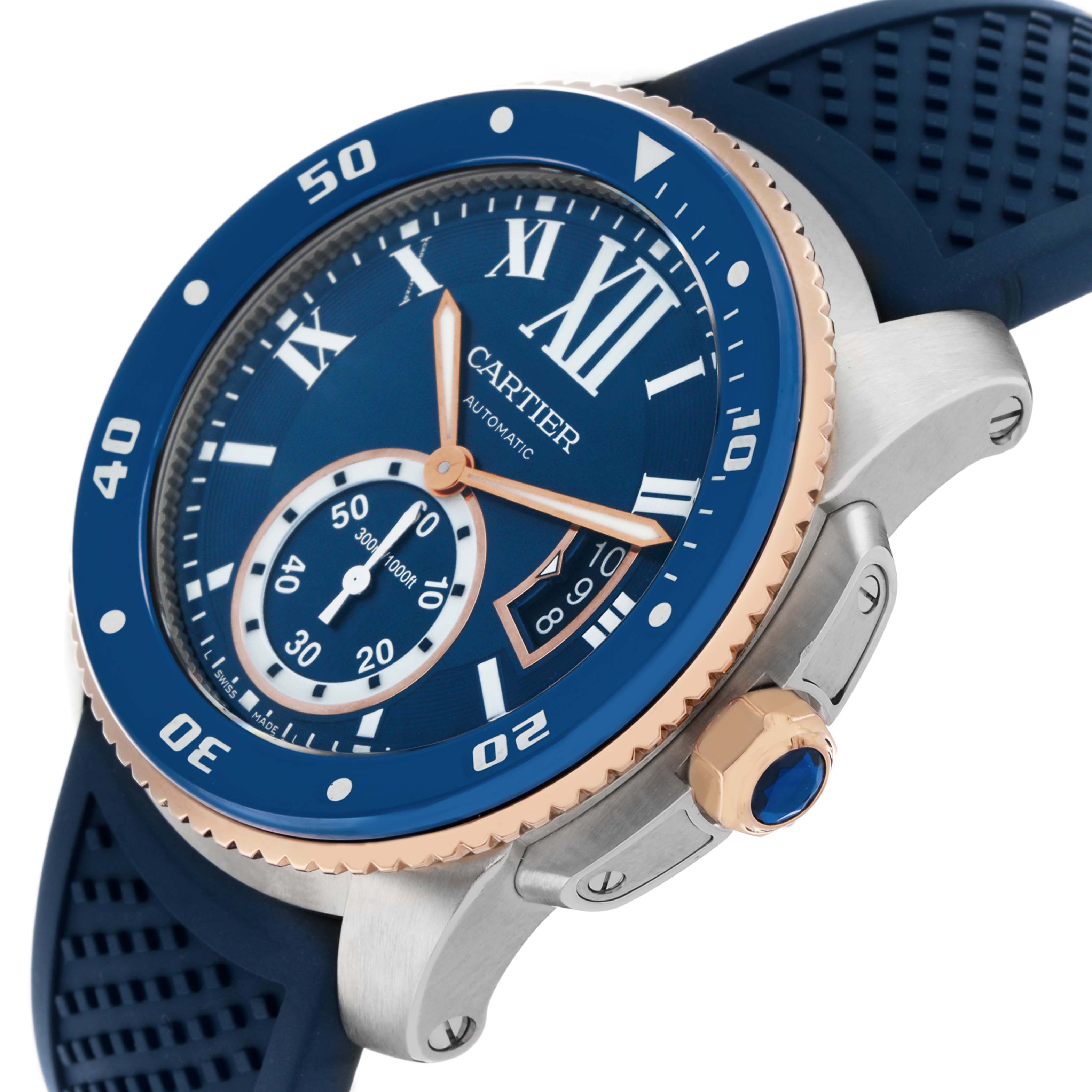 The Calibre de Cartier watch is shown at an oblique angle, highlighting the blue dial, bezel, and rubber strap.
