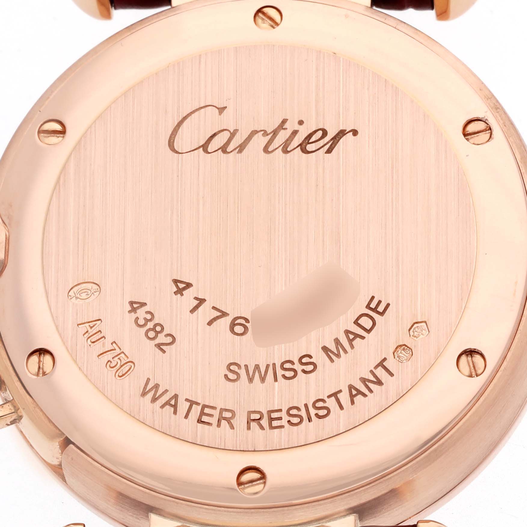 The image shows the back case of a Cartier Pasha WJPA0017 Women's Rose Gold Silver Dial watch, highlighting the brand name, serial numbers, and other engravings.