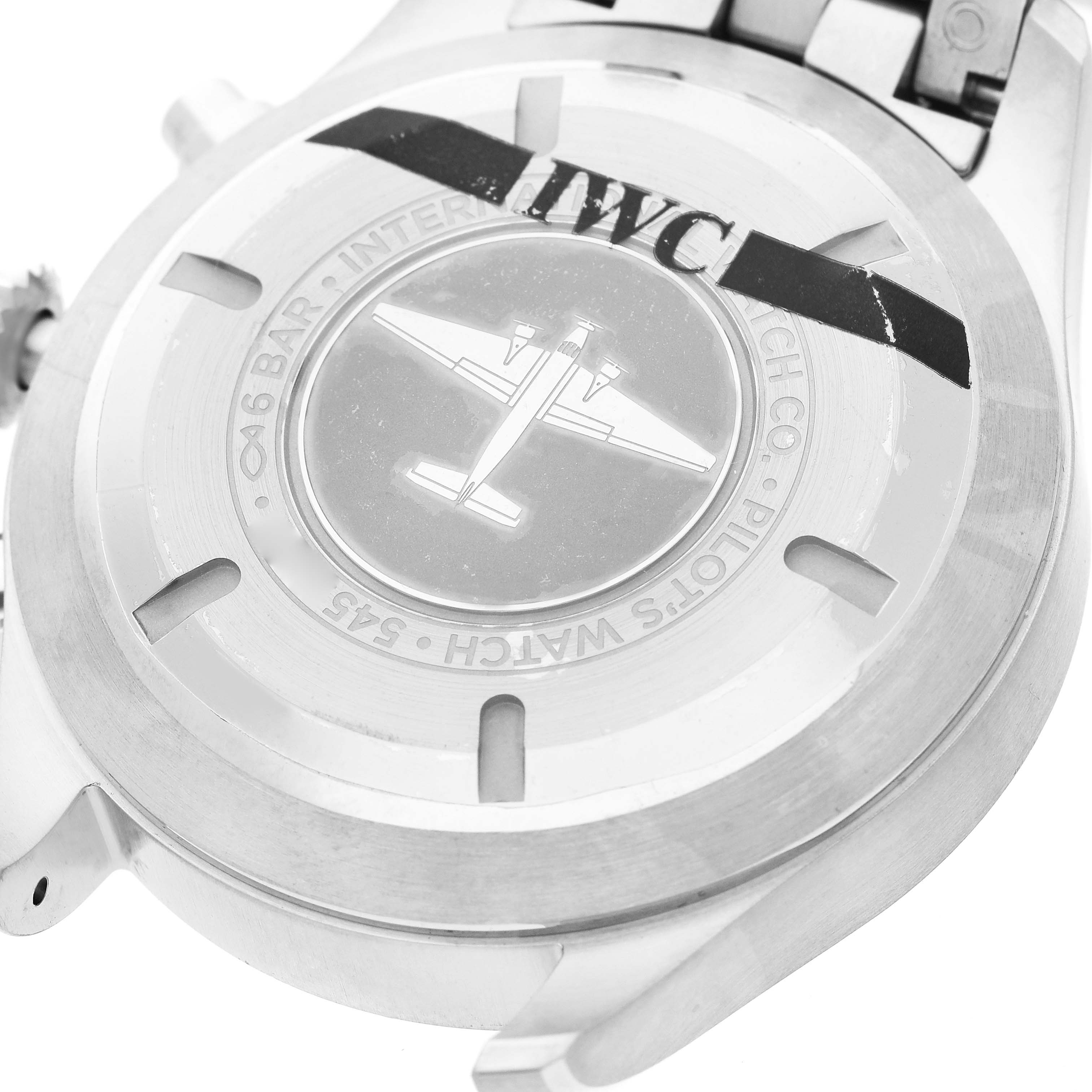 The image shows the back case of an IWC Pilot IW377710 Men's Stainless Steel Black Dial watch featuring a plane engraving and brand markings.