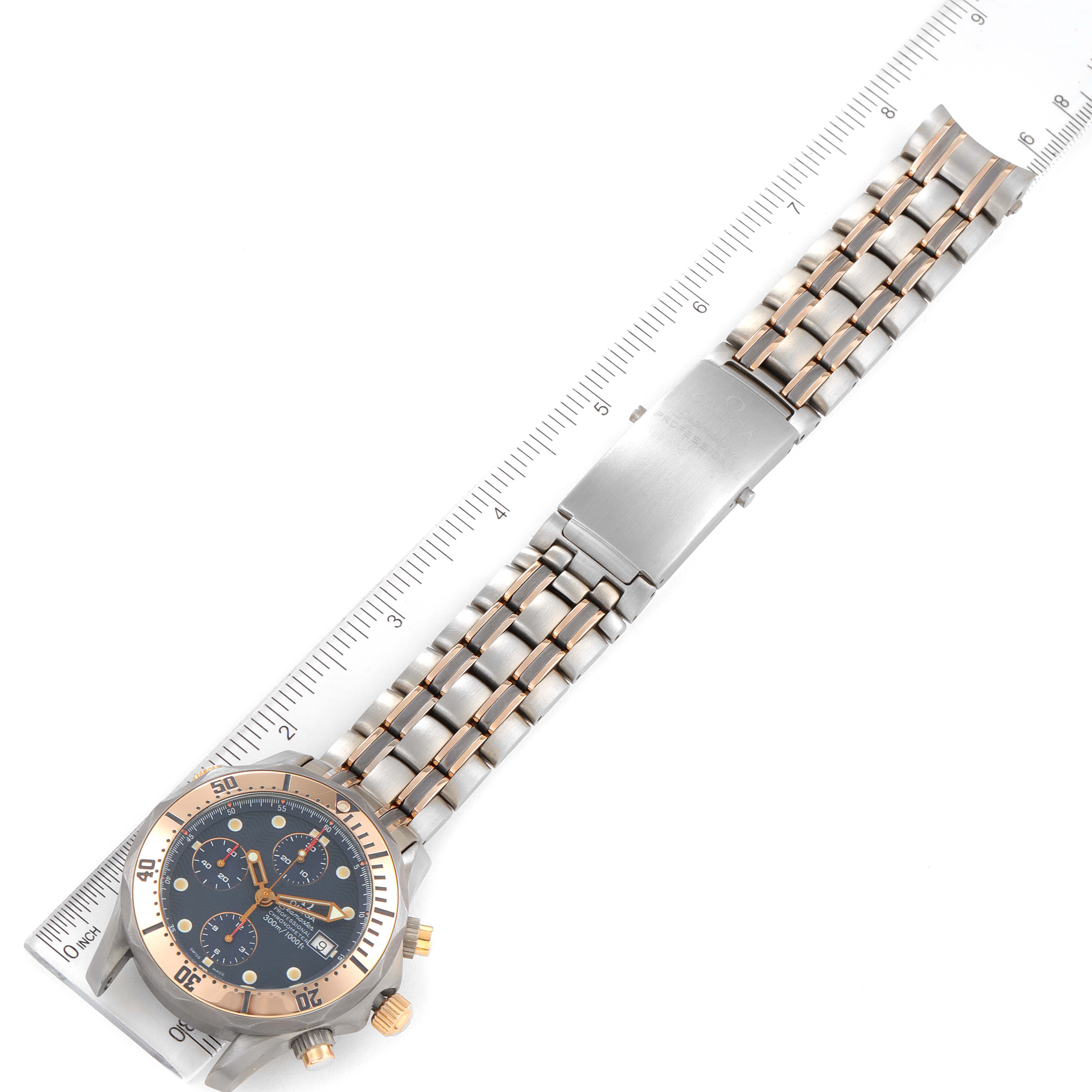 The image shows a metal bracelet Omega Seamaster 2296.80.00 Men's Titanium Blue Dial 2296.80.00 Men's Titanium Blue Dial watch laid flat next to a ruler, displaying its face, strap, and clasp.