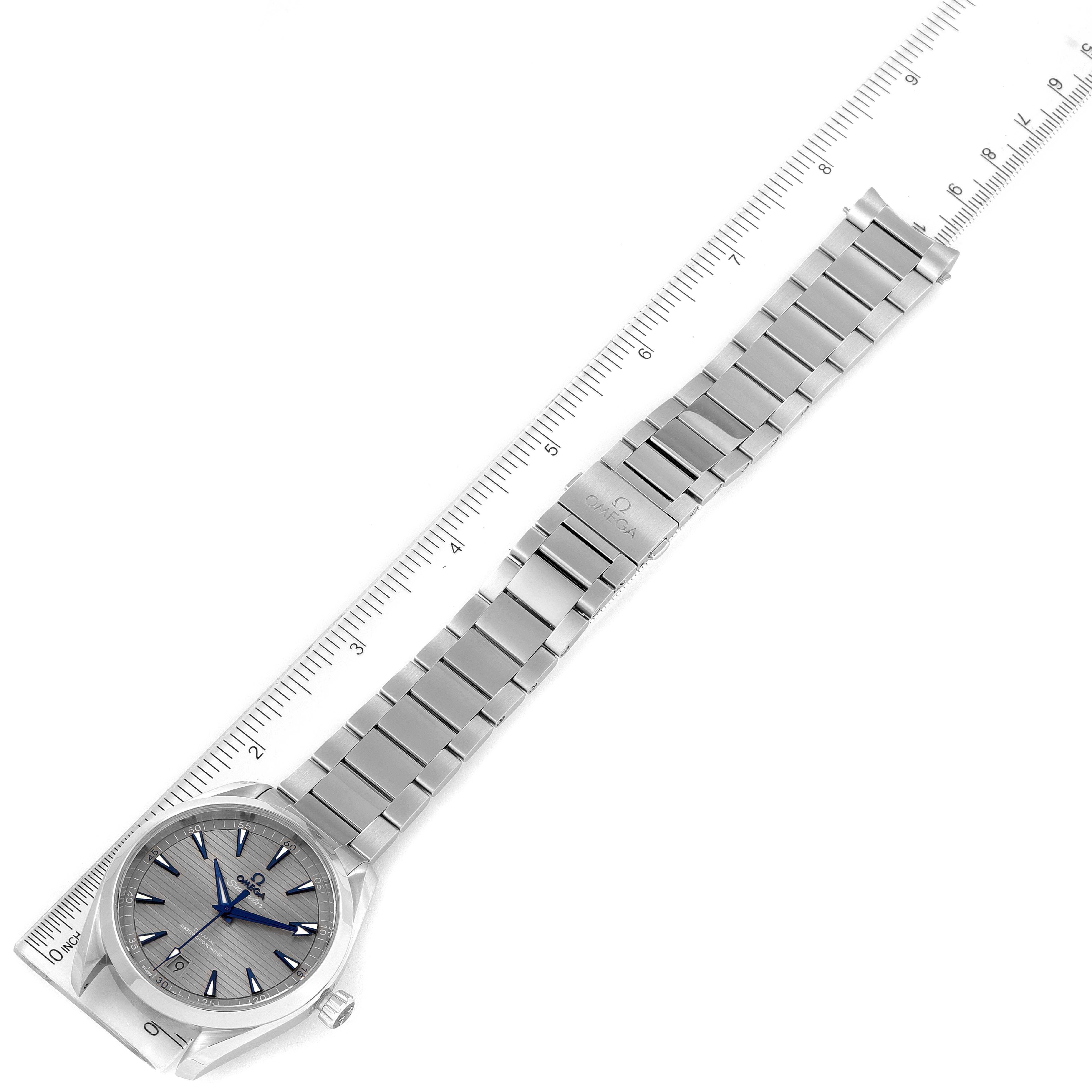 The image shows an Aqua Terra model by Omega from a top-down angle, featuring the full watch and a measuring ruler adjacent to it.
