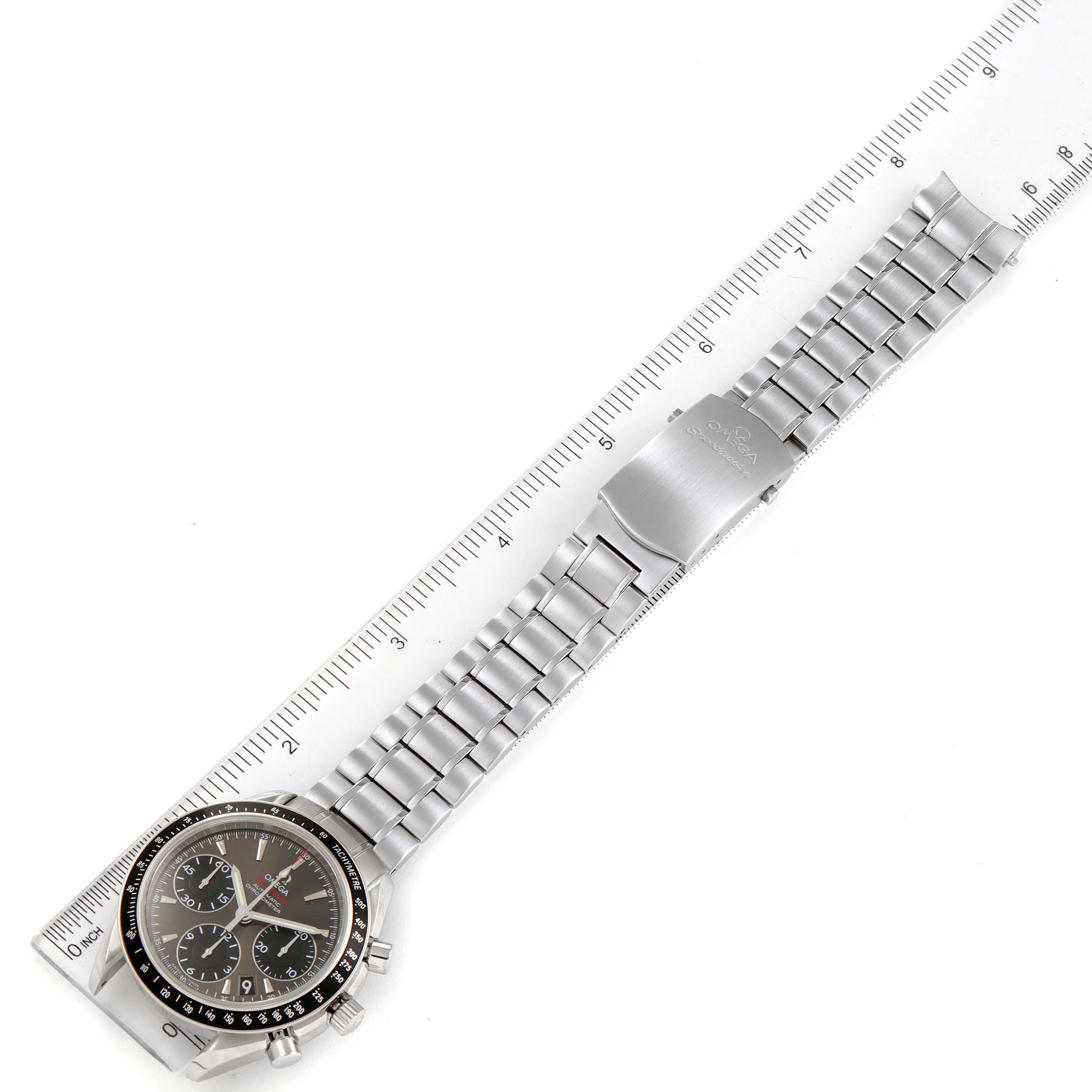 The Omega Speedmaster 323.30.40.40.06.001 Men's Stainless Steel Grey Dial 323.30.40.40.06.001 Men's Stainless Steel Grey Dial watch is shown from a top-down angle, displaying the face, bracelet, and clasp, with a ruler for scale.