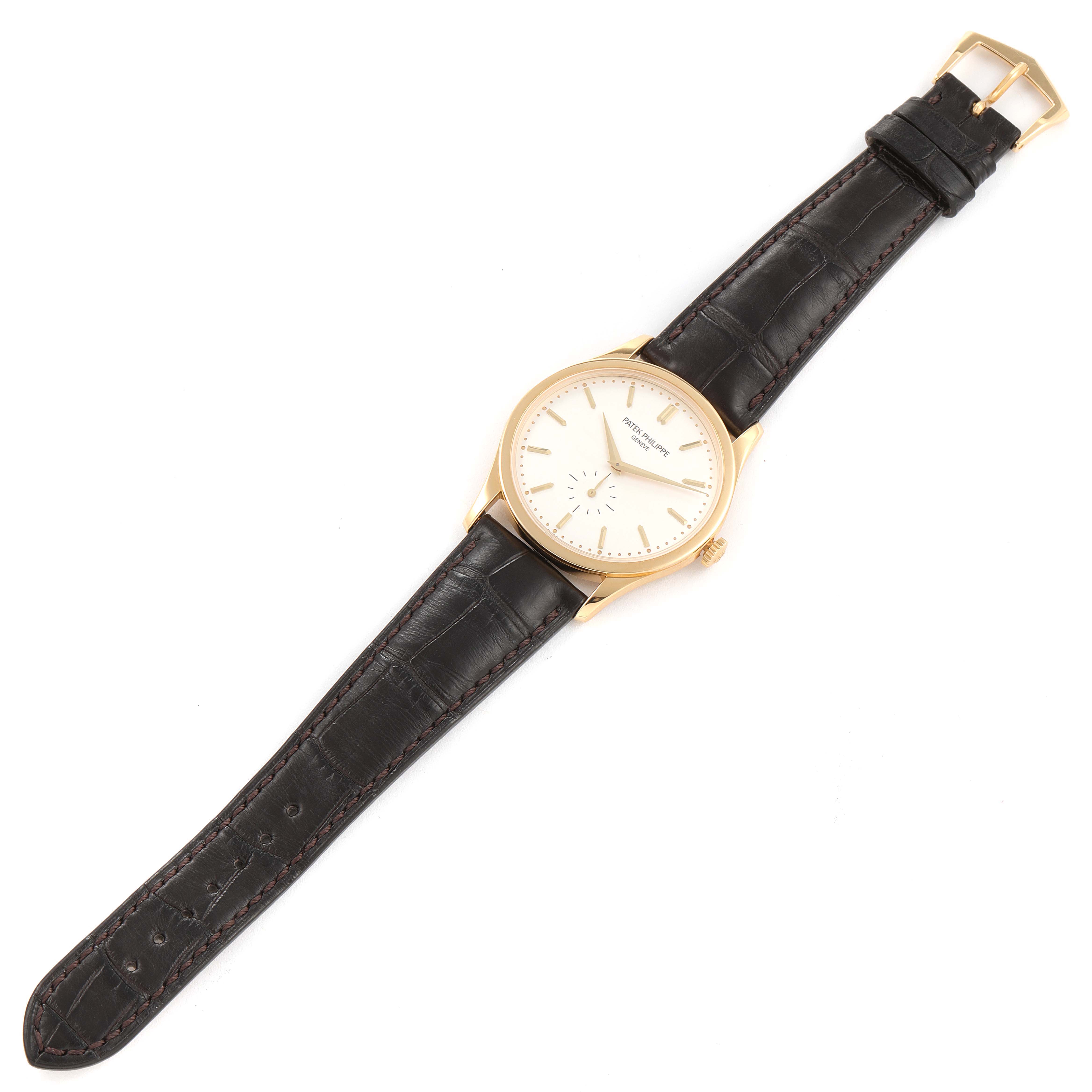 This image shows a Patek Philippe Calatrava 5196J Men's Yellow Gold Silver Dial 5196J Men's Yellow Gold Silver Dial watch from a top-down angle, displaying the face, case, crown, and leather strap.