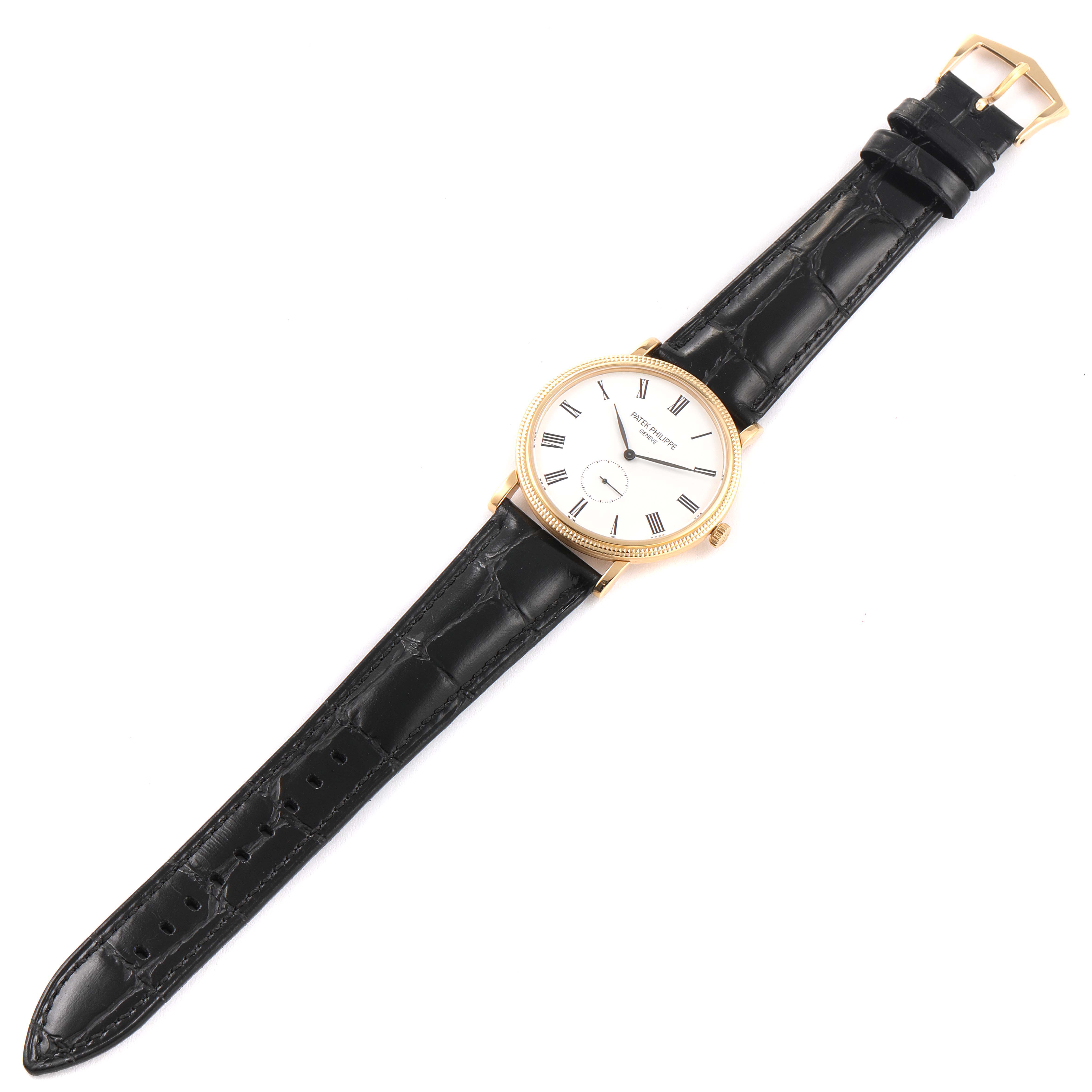 The image shows a Patek Philippe Calatrava 5119J Men's Yellow Gold White Dial 5119J Men's Yellow Gold White Dial watch from a top-down angle, highlighting its dial, case, and leather strap.