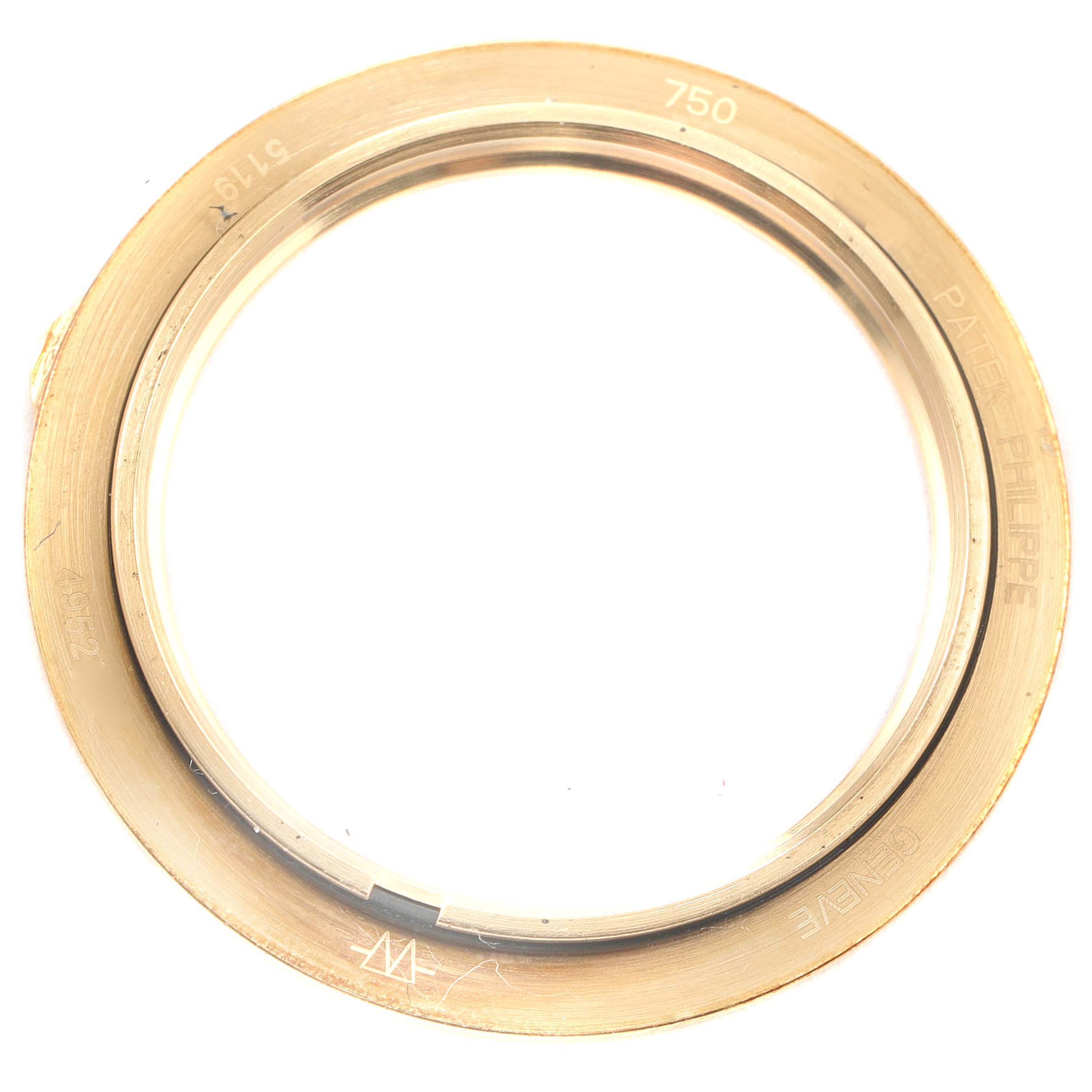 This image shows the gold bezel of a Patek Philippe Calatrava 5119J Men's Yellow Gold White Dial 5119J Men's Yellow Gold White Dial model watch from a top-down angle.