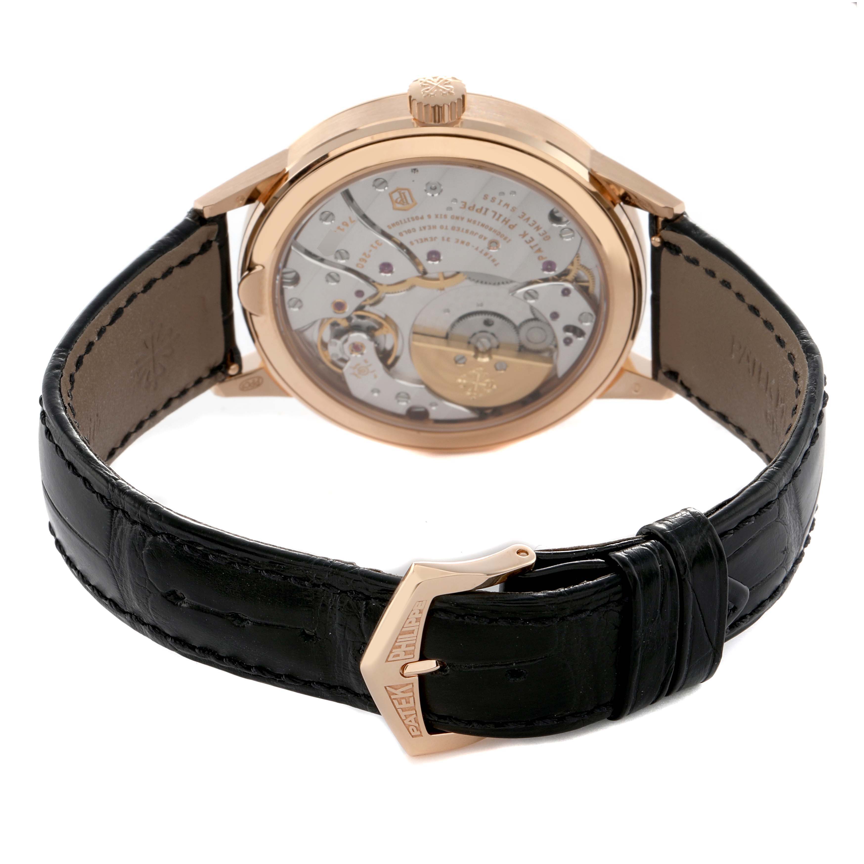 The Patek Philippe Complications 5235/50R-001 Men's Rose Gold Grey Dial watch is shown from the back, displaying the movement and a leather strap with a branded clasp.