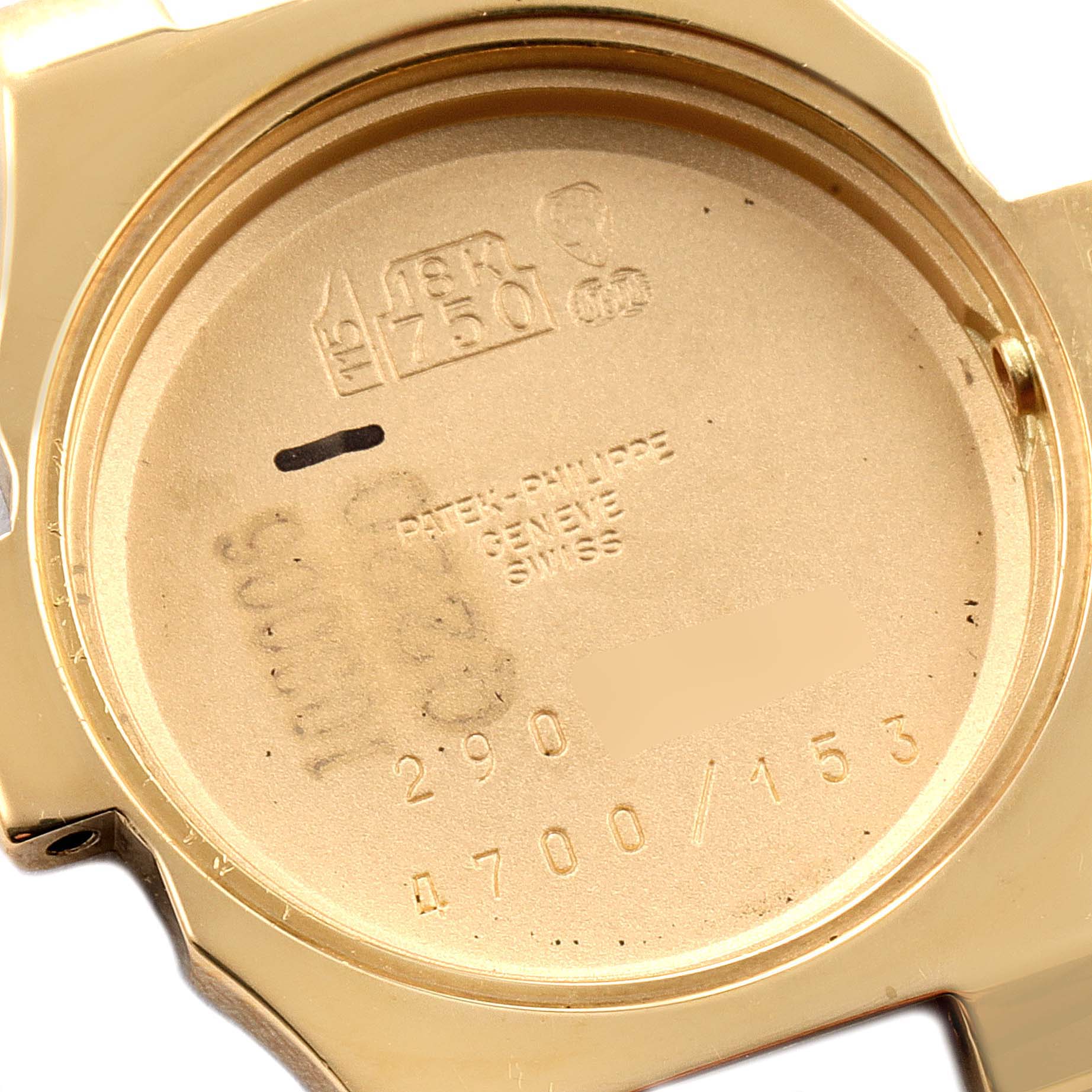 This image shows the back case of a Patek Philippe Nautilus 4700/153 Women's Yellow Gold Champagne Dial 4700/153 Women's Yellow Gold Champagne Dial watch, highlighting its engravings and hallmarks.