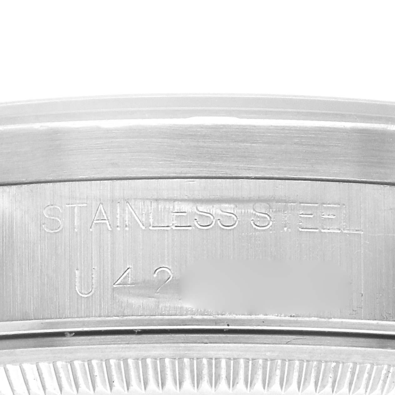 The image shows the engraved edge of a Rolex Air-King 14010 Men's Stainless Steel White Dial 14010 Men's Stainless Steel White Dial watch case, featuring "STAINLESS STEEL" text.
