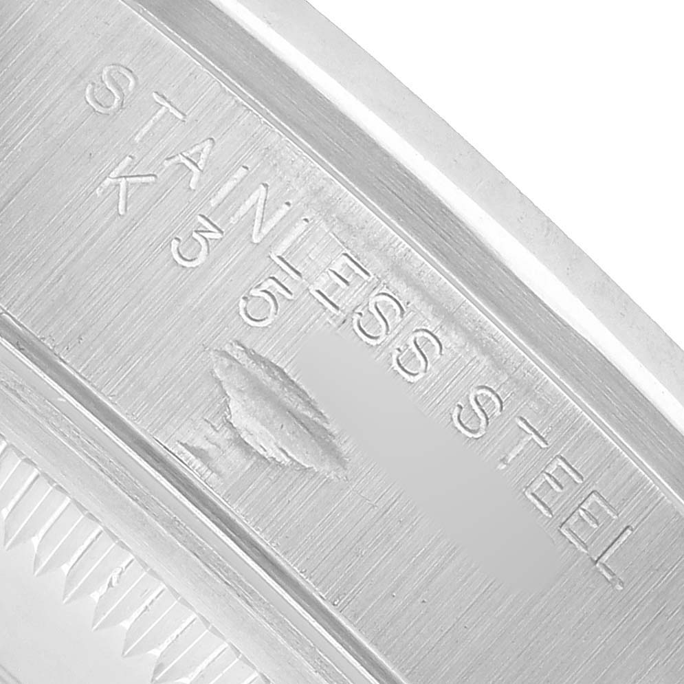 The image shows a macro close-up of the Rolex Date ROLEX DATE BLACK DIAL SMOOTH BEZEL STEEL MENS WATCH 15200 Men's Stainless Steel Black Dial model's stainless steel inner case with engraving details.