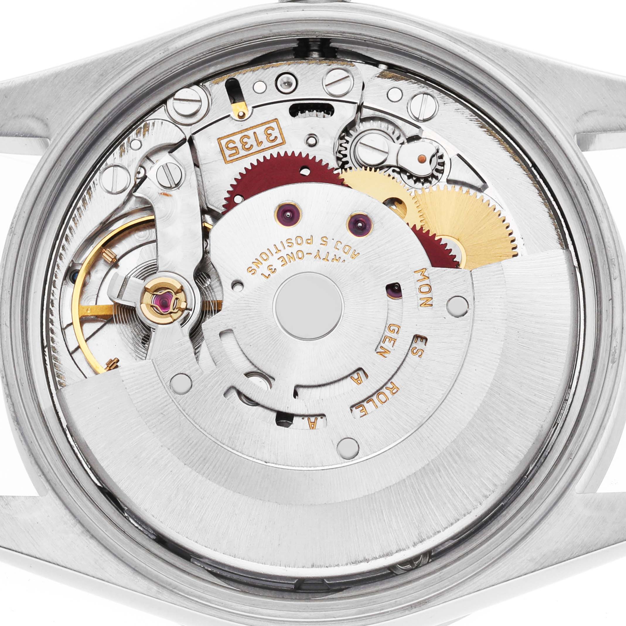 The image shows the movement of a Rolex Date 15210 Men's Stainless Steel Silver Dial model from the back, highlighting gears and mechanical components.