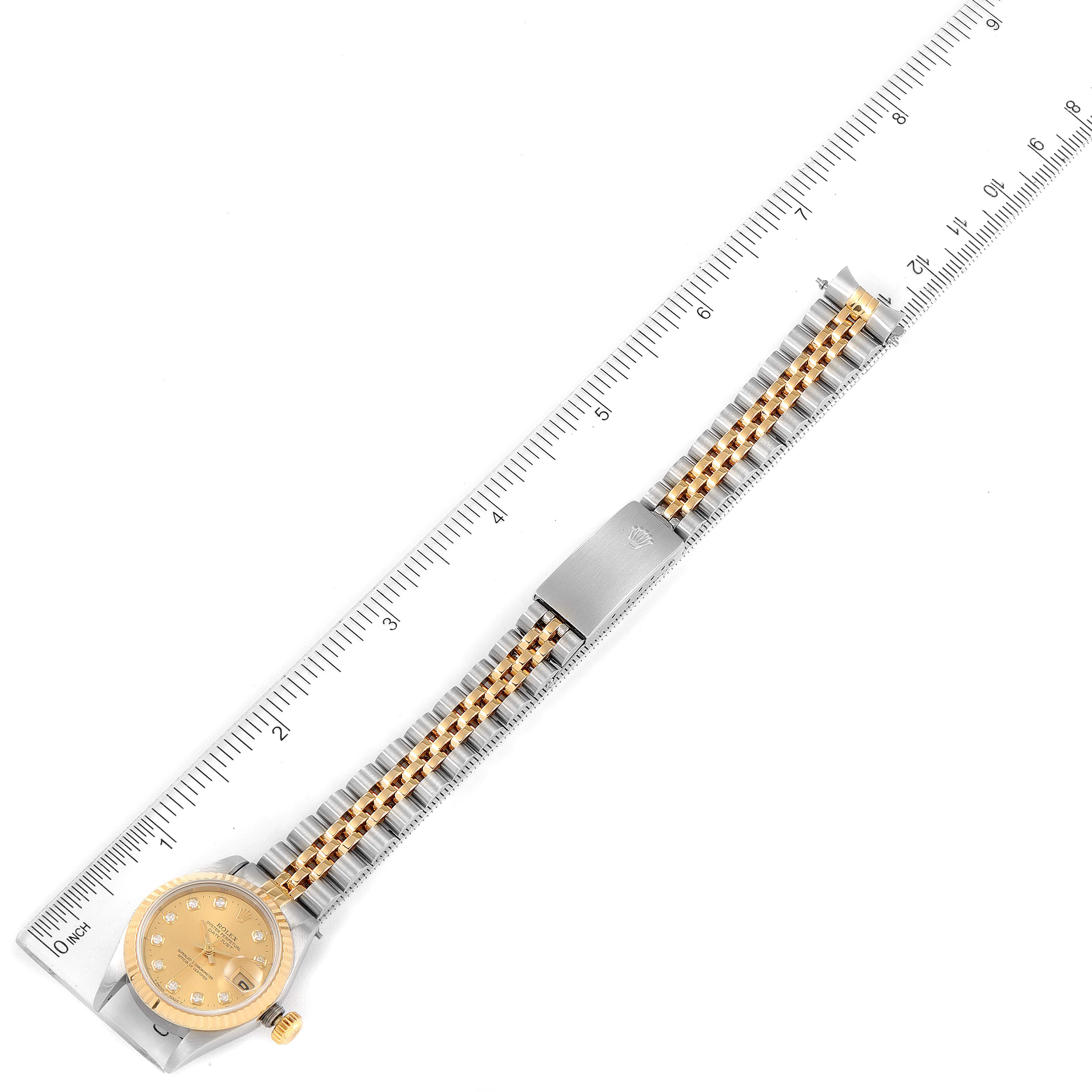 This image shows a Rolex Datejust 69173 Women
s Steel and Gold (two tone) Champagne Dial 69173 Women
s Steel and Gold (two tone) Champagne Dial watch from top view, displaying the face, bracelet, and part of the clasp, with a ruler for scale.