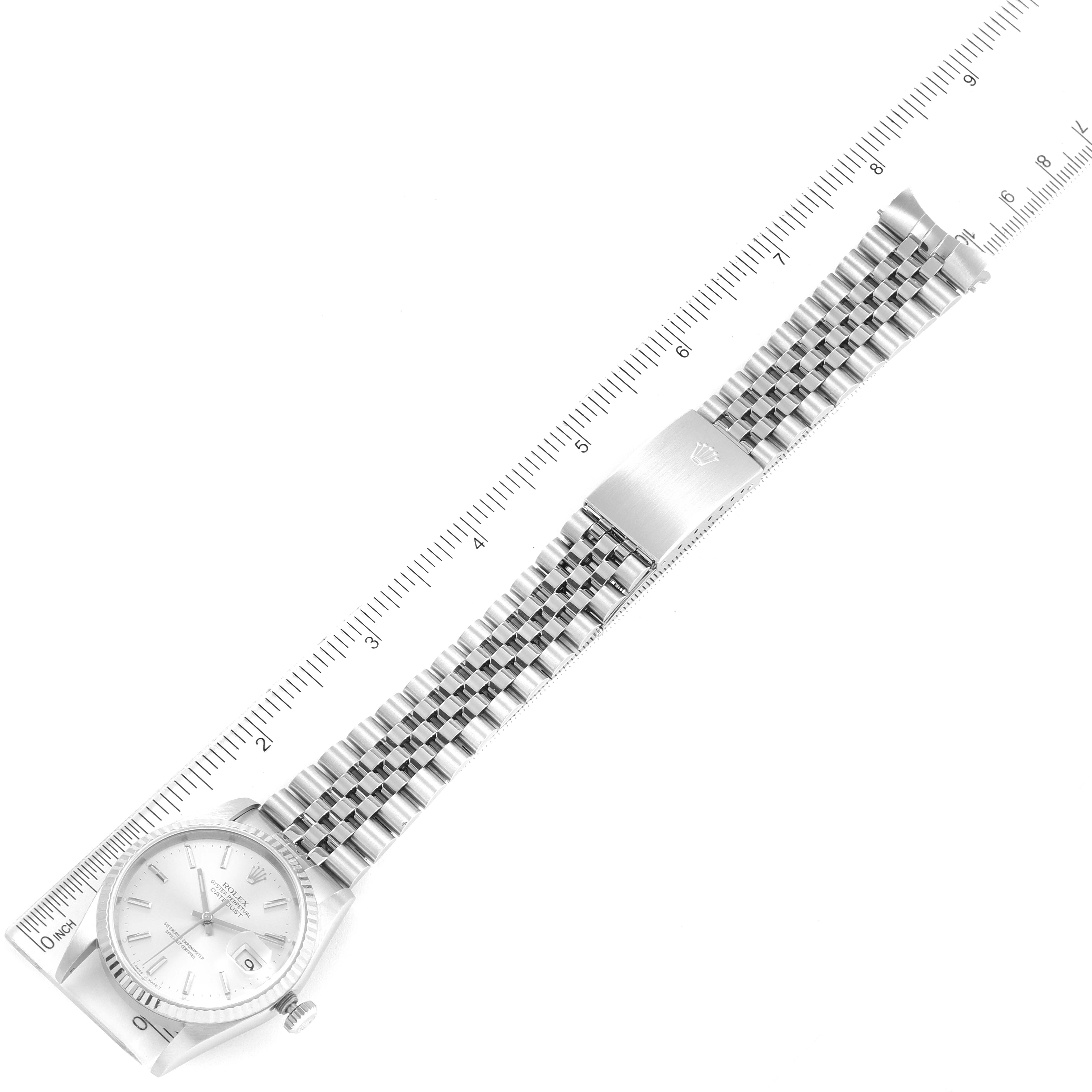 The image shows a top view of a Rolex Datejust 16234 Men's Stainless Steel Silver Dial 16234 Men's Stainless Steel Silver Dial watch, highlighting the watch face, bracelet, and clasp beside a ruler for scale.