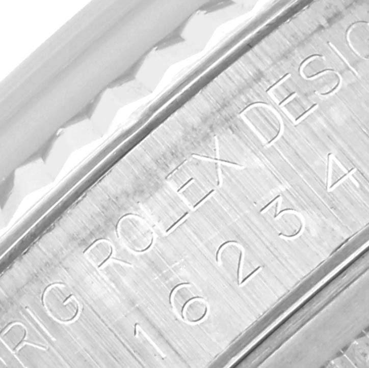 The image focuses on the side engraving of the Rolex Datejust 16234 Men's Stainless Steel Silver Dial 16234 Men's Stainless Steel Silver Dial, showing the serial number and "Rolex Design" marking.