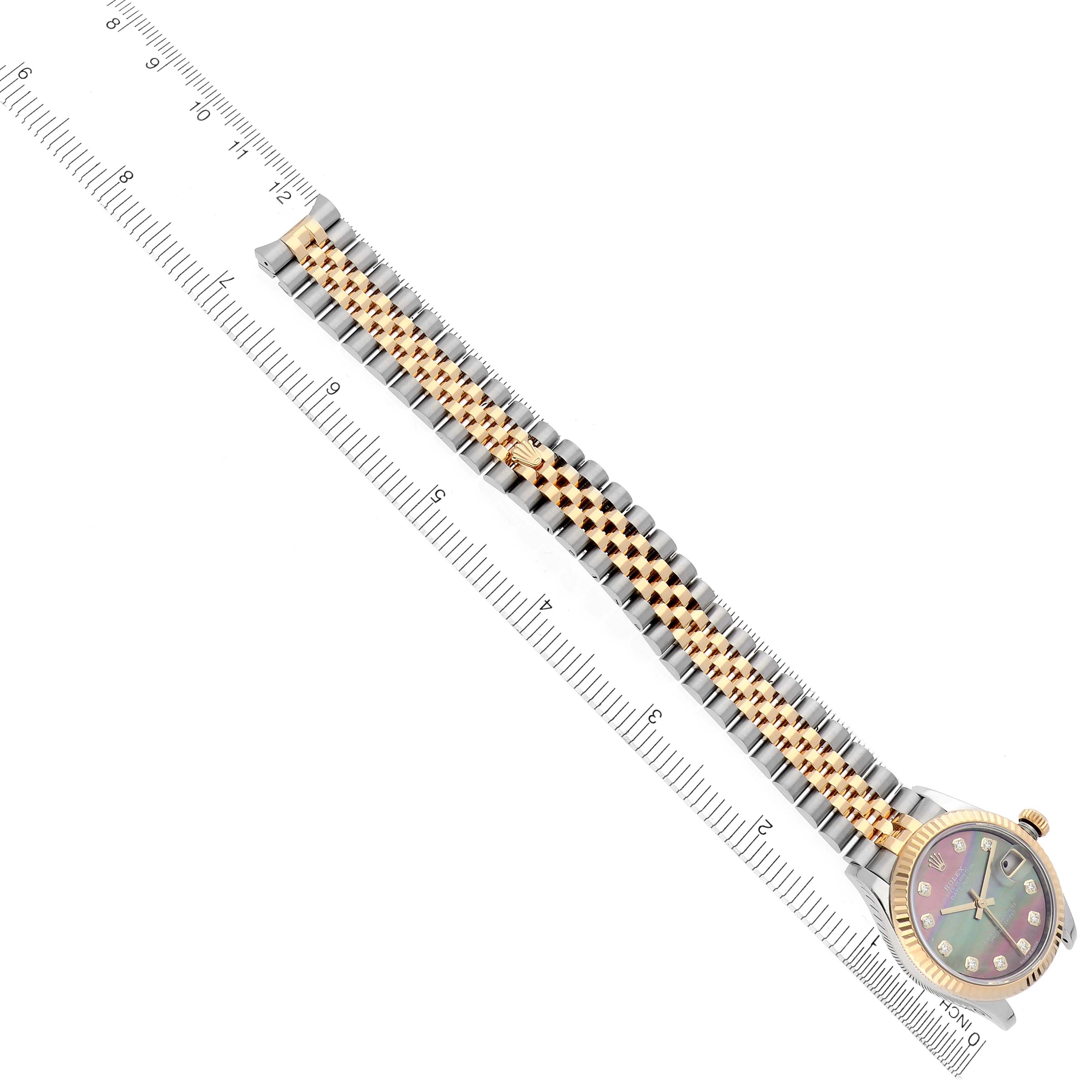 The image shows a side view of a Rolex Mid-Size 278273 Women's Steel and Gold (two tone) Mother of Pearl Dial 278273 Women's Steel and Gold (two tone) Mother of Pearl Dial watch with a gold and silver bracelet next to a ruler for scale.