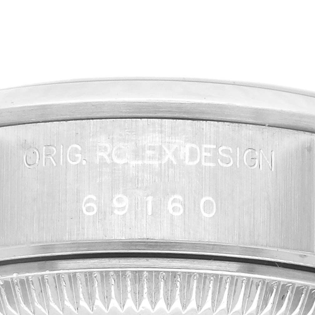 The image shows the side of the Rolex Datejust 69160 Women's Stainless Steel Pink Dial 69160 Women's Stainless Steel Pink Dial case with engraved details, including the model number.