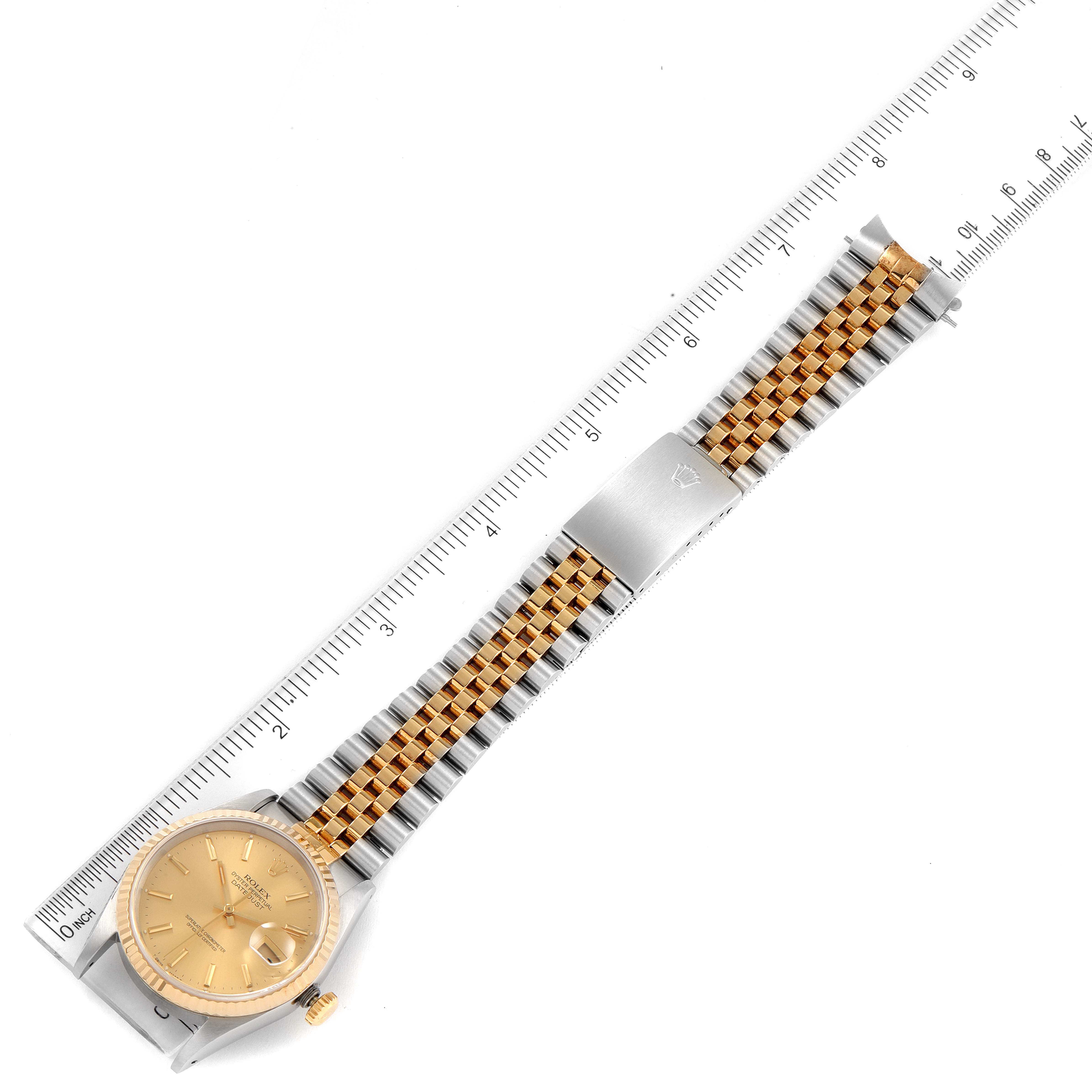 The Rolex Datejust 16233 Men
s Steel and Gold (two tone) Champagne Dial 16233 Men
s Steel and Gold (two tone) Champagne Dial watch is shown fully extended with its two-tone band and clasp visible, measured against a ruler.