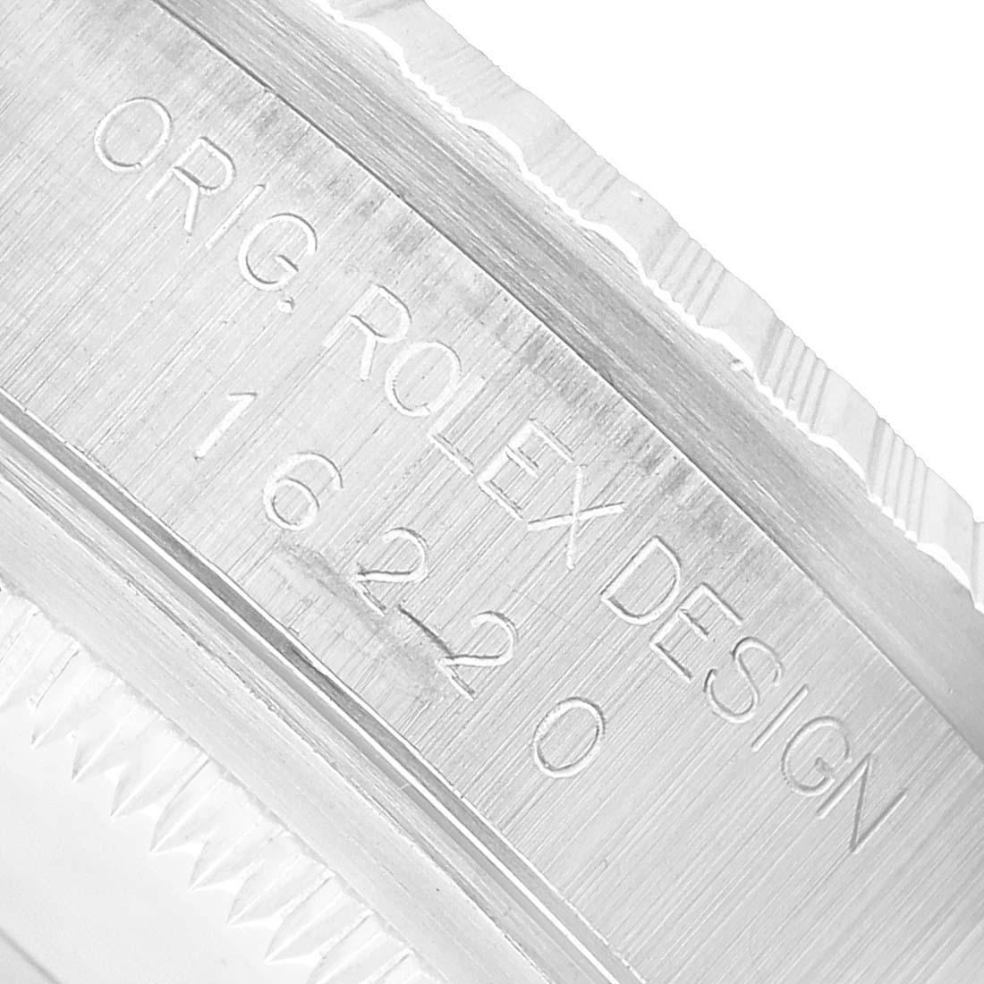 The image shows a close-up of the side of a Rolex Datejust 16220 Men's Stainless Steel Silver Dial watch case, featuring engraved text.