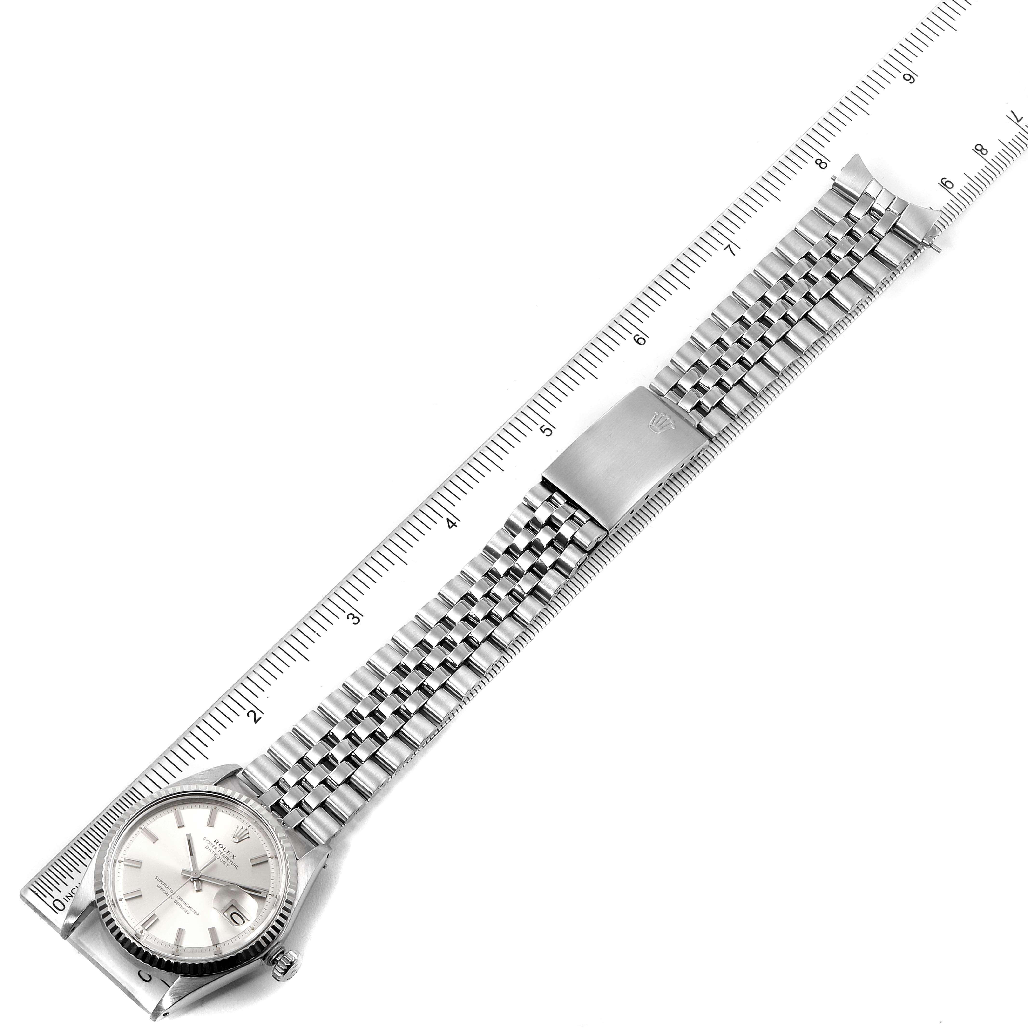 This Rolex Vintage Collection 1601 Men
s Stainless Steel Silver Dial 1601 Men
s Stainless Steel Silver Dial watch is shown fully extended, displaying the dial, bracelet, and clasp, positioned against a ruler for scale.