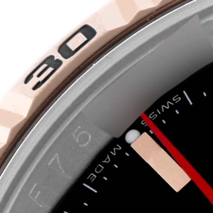 The image shows a close-up of the Rolex Turn-o-Graph 116261 Men's Steel and Gold (two tone) Black Dial 116261 Men's Steel and Gold (two tone) Black Dial watch bezel and part of the dial, including the red second hand.