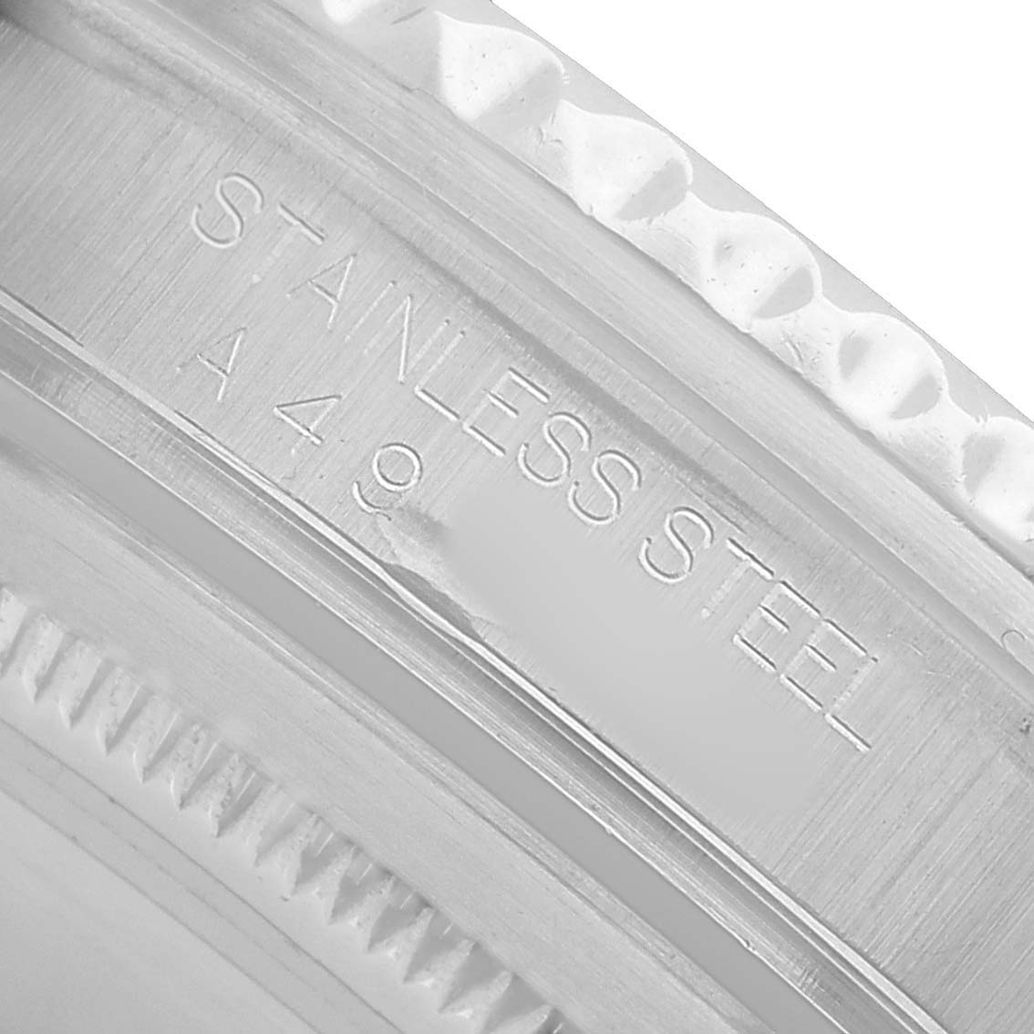 The image shows a close-up of the side engraving on the bezel of a Rolex GMT-Master 16700 Men's Stainless Steel Black Dial, highlighting "STAINLESS STEEL."