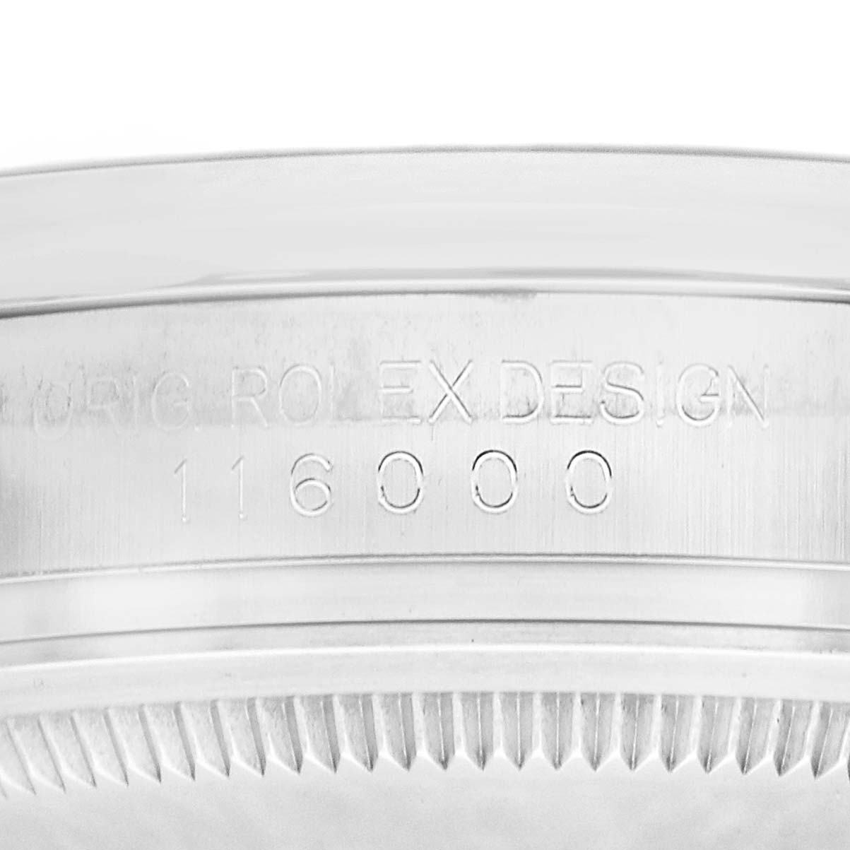 The image shows the edge of a Rolex Oyster Perpetual 116000 Men's Stainless Steel Silver Dial watch case, focusing on the bezel and engraved model number.