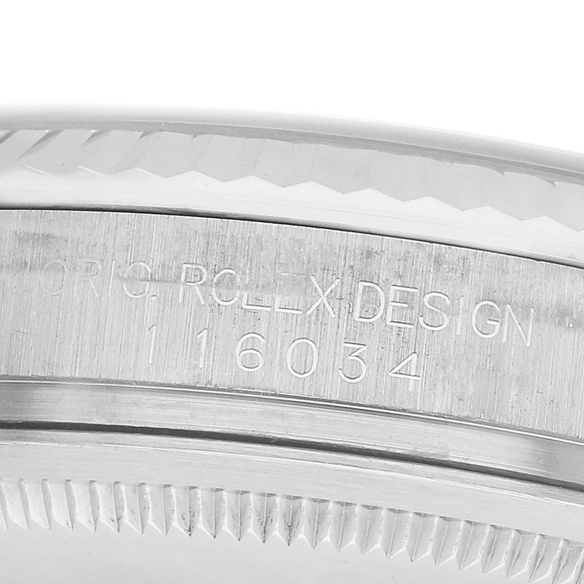The image shows the side engraving on the bezel of a Rolex Oyster Perpetual 116034 Men's Stainless Steel White Dial, focusing on the model number and design inscription.