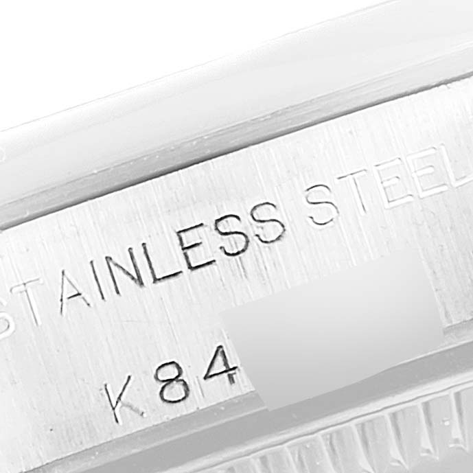 This image shows a close-up view of the engraved stainless steel case of a Rolex Oyster Perpetual 76080 Women's Stainless Steel Silver Dial 76080 Women's Stainless Steel Silver Dial watch.