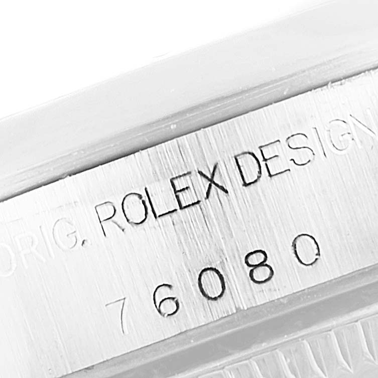 This image shows a close-up of the serial number and "ROLEX DESIGN" engraving on an Oyster Perpetual model watch by Rolex.