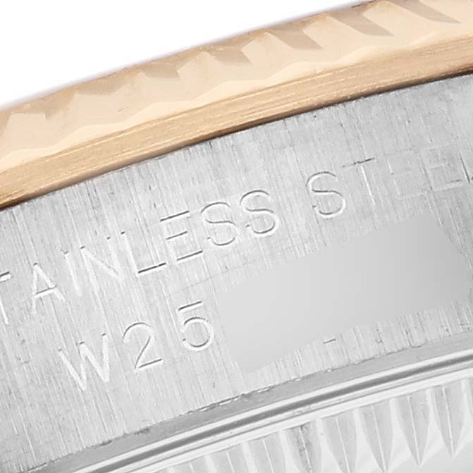 The image shows a close-up of the bezel and case side of a Rolex Oyster Perpetual 67193 Women's Steel and Gold (two tone) Champagne Dial 67193 Women's Steel and Gold (two tone) Champagne Dial, highlighting the stainless steel engraving.