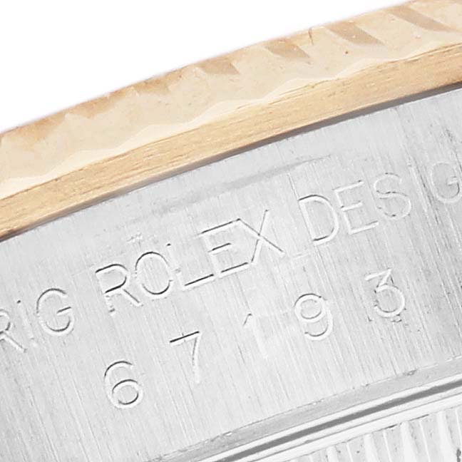 The image shows a close-up of the engraved side of the Rolex Oyster Perpetual 67193 Women's Steel and Gold (two tone) Champagne Dial 67193 Women's Steel and Gold (two tone) Champagne Dial watch, detailing its design and model number.