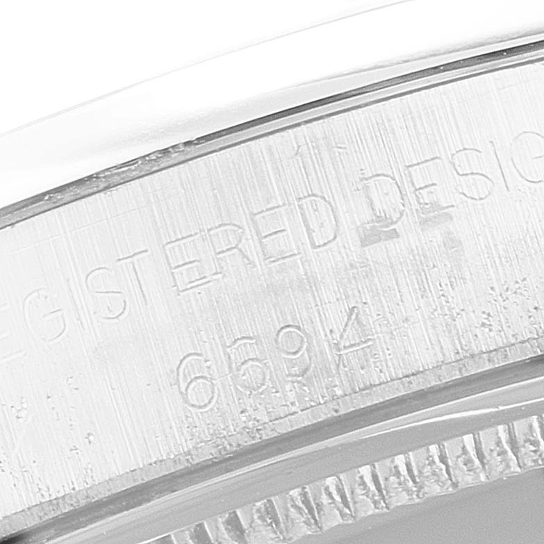 The image shows a close-up of the bezel and serial number engraving on the side of a Rolex Vintage Collection 6694 Men's Stainless Steel Silver Dial 6694 Men's Stainless Steel Silver Dial watch.