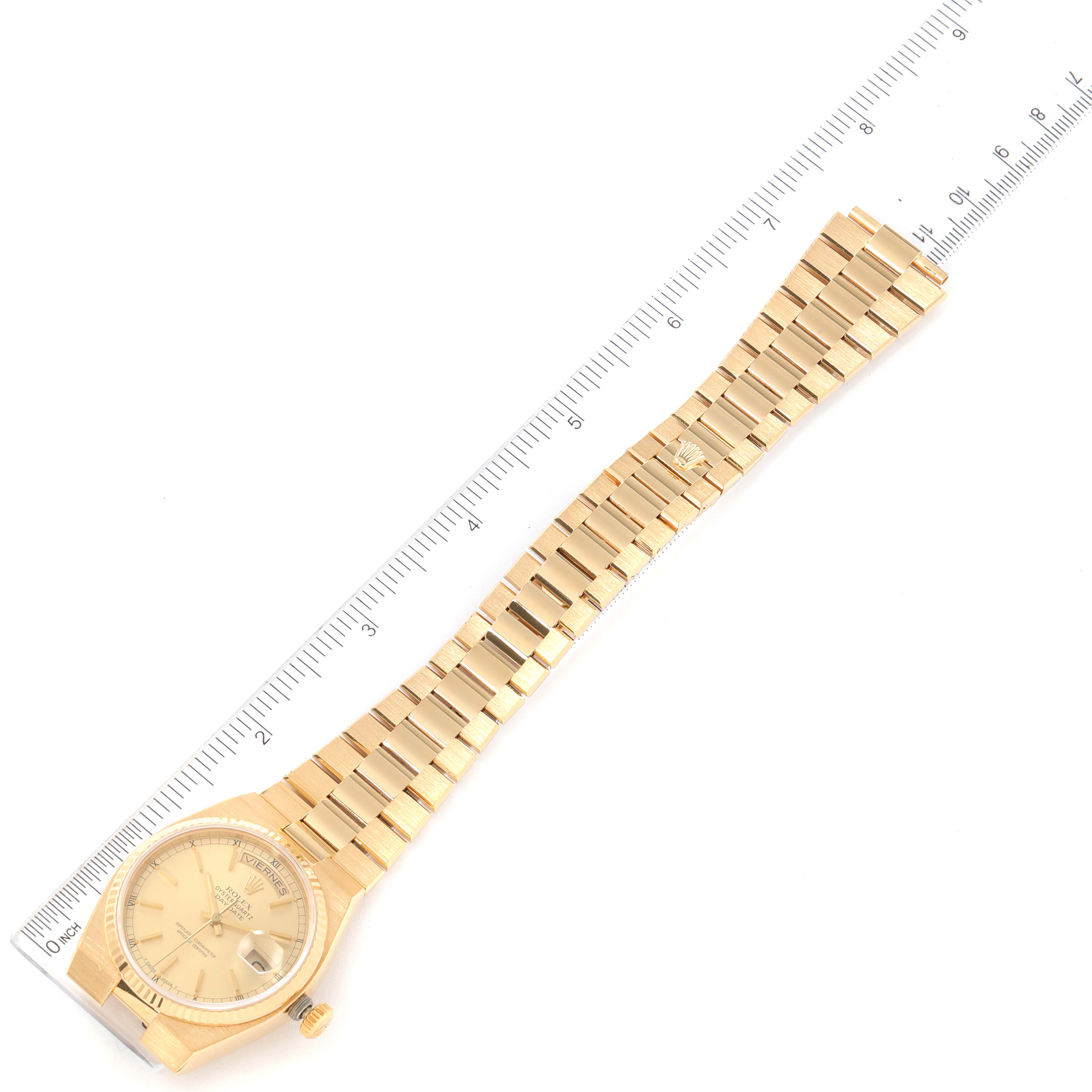 The Rolex President 19018 Men
s Yellow Gold Champagne Dial 19018 Men
s Yellow Gold Champagne Dial model watch is shown from a top-down angle, displaying the entire band and face against a ruler for scale.