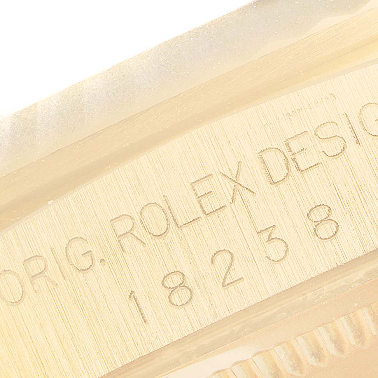 This image shows a close-up of the engraved serial number and the "ORIG. ROLEX DESIGN" text on the side of a Rolex President 18238 Men's Yellow Gold Champagne Dial 18238 Men's Yellow Gold Champagne Dial model watch.