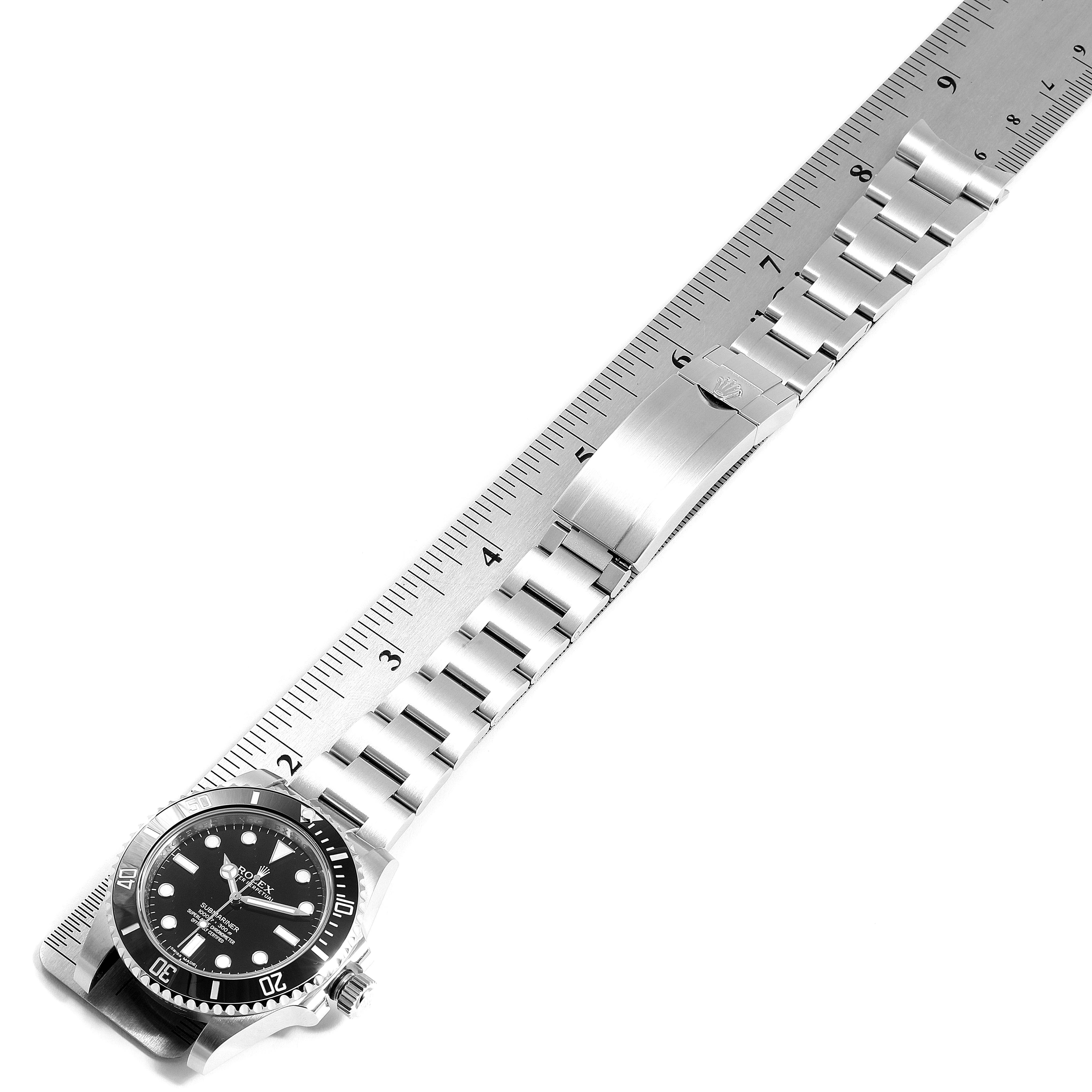 The image shows a top-down view of the Rolex Submariner 114060 Men
s Stainless Steel Black Dial 114060 Men
s Stainless Steel Black Dial watch, focusing on the clasp and bracelet laid next to a ruler.