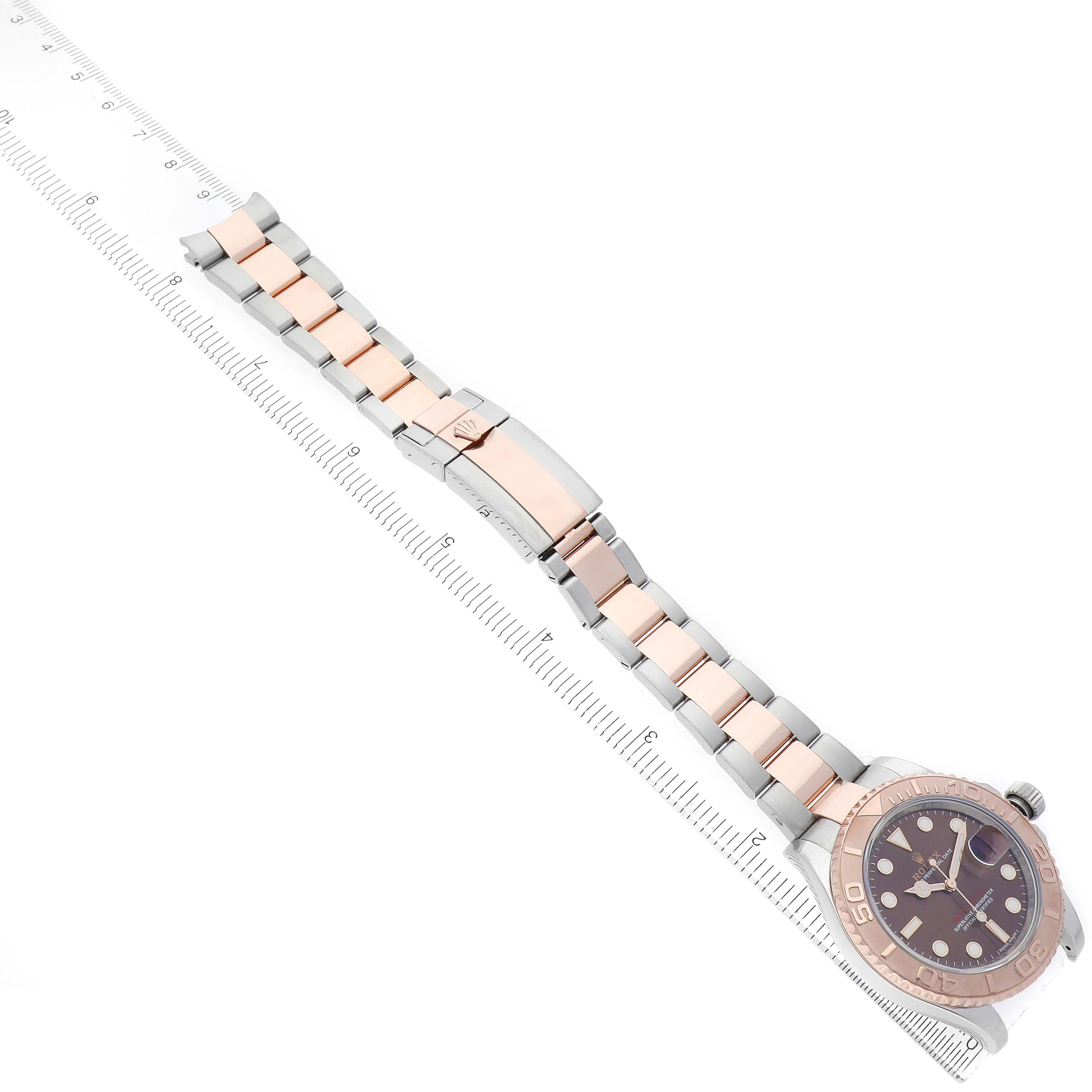The Rolex Yacht-Master 116621 Men's Steel and Gold (two tone) Brown Dial watch is shown from a top-down angle, displaying the face, bezel, bracelet, and clasp.